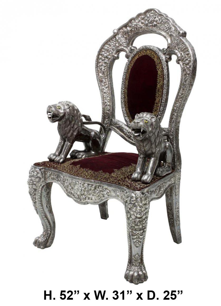 Anglo-Indian silver embossed throne chair with lion arm rests, late 19th century.

The armchair is with an oval padded back, surmounted with an arched cresting conjoined with outset stiles, the back is decorated with repousse work in a foliate and