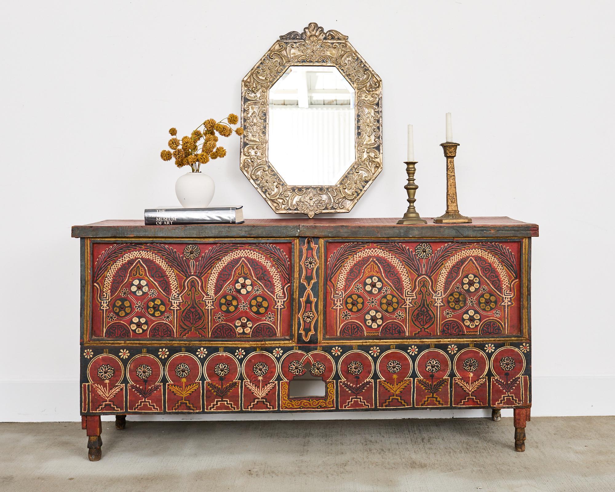 Miroir octogonal biseauté de style anglo-indien, avec un travail de métal repoussé et martelé à la main dans les tons d'argent. Le miroir a un cadre en bois laqué noir décoré d'une façade en repoussé avec des motifs floraux et des volutes.