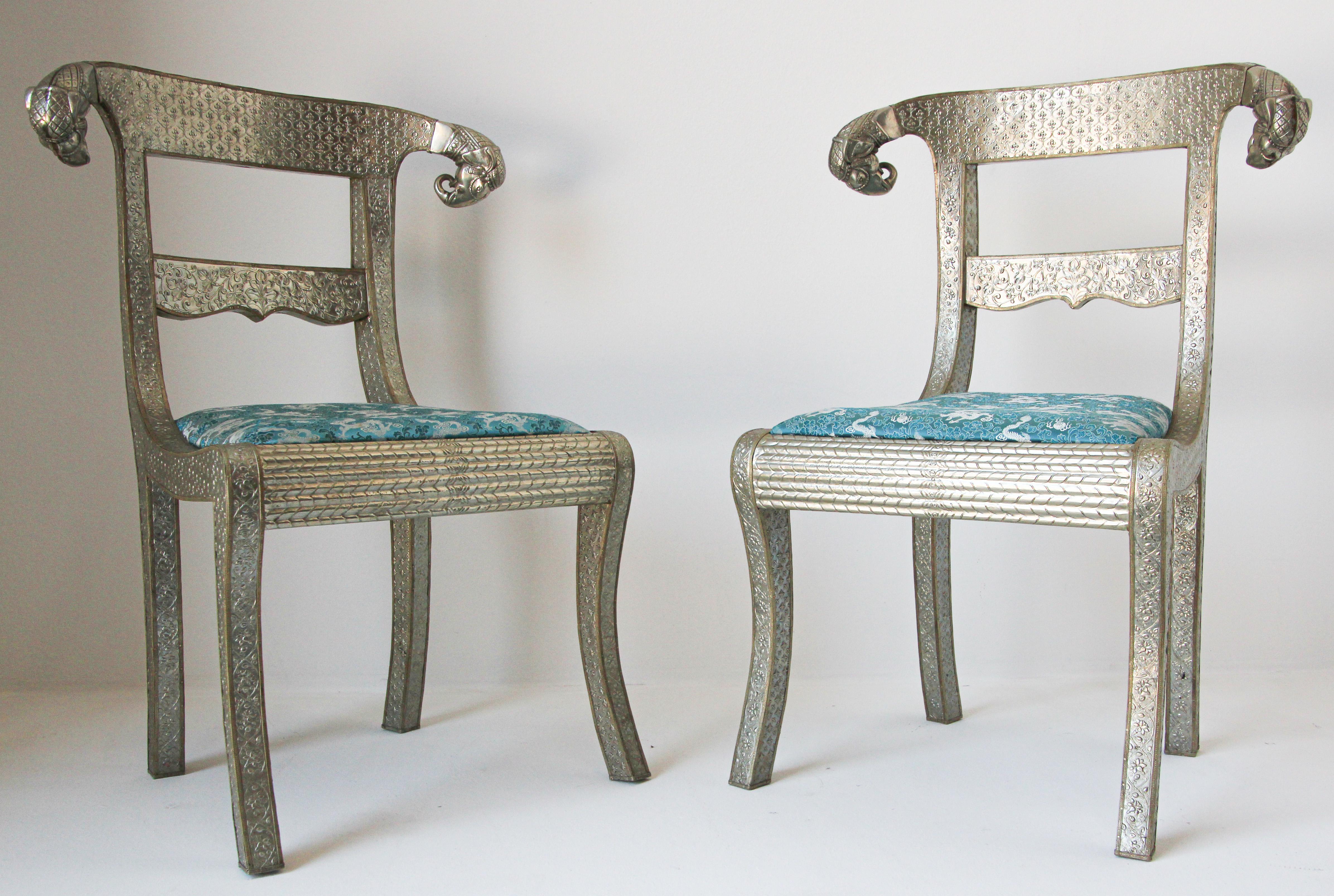 Set of tow Anglo-Indian silvered wrapped clad side chairs.
Anglo Raj wedding palace chair, hand-hammered with repousse silver metal work over wood with carved elephant head finals and blue cushion, very nice and unusual.
Vintage Anglo-Indian