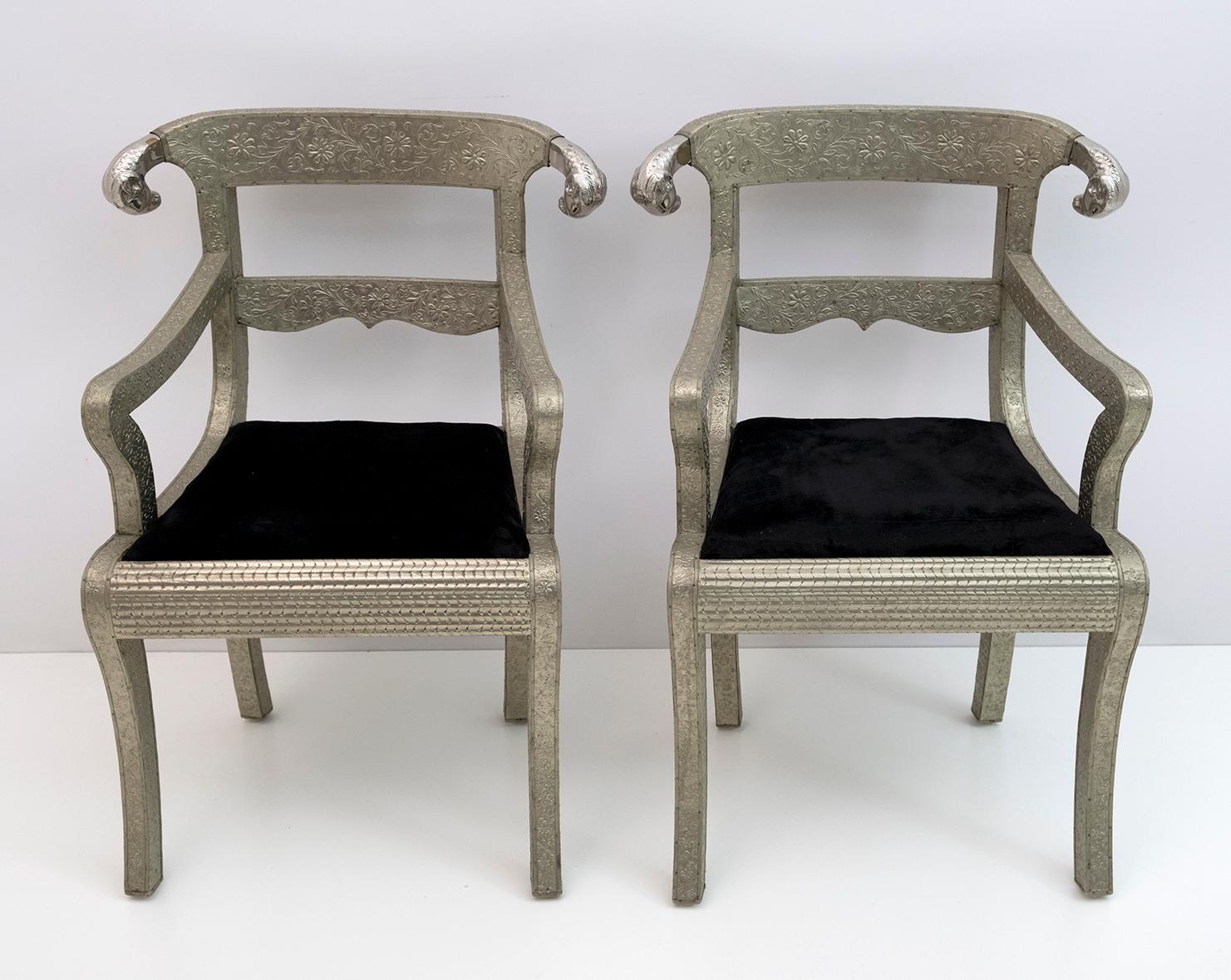 Ensemble de deux chaises d'appoint rembourrées en argent anglo-indien.
Chaise de palais de mariage Anglo Raj, martelée à la main avec un travail de métal argenté en relief sur du bois avec des extrémités sculptées en tête de bélier et un coussin