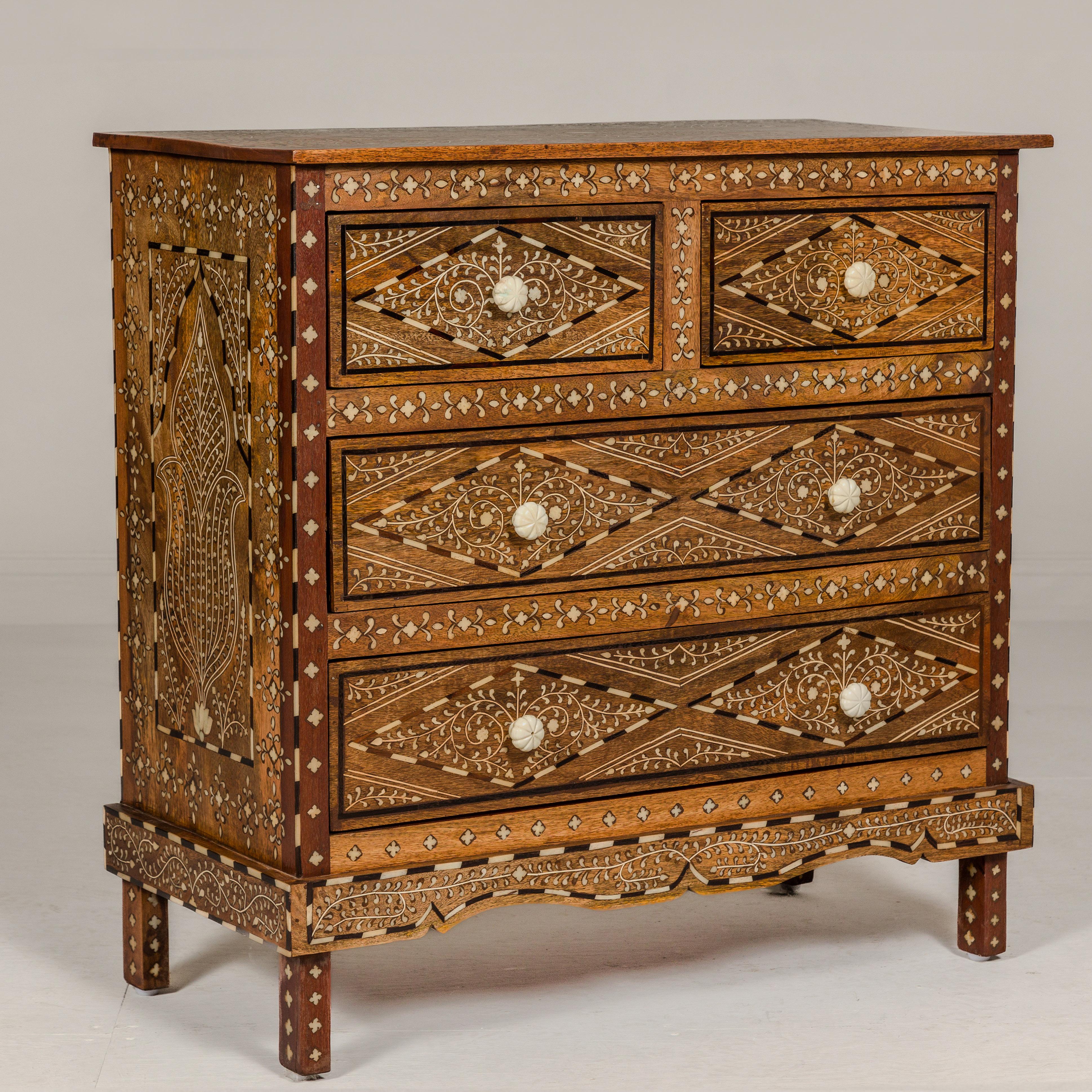 An Anglo-Indian style four-drawer chest with foliage-themed bone inlaid décor. This Anglo-Indian style four-drawer chest is an exquisite embodiment of craftsmanship and artistry. Its allure lies in the meticulous bone inlay work, which adorns the
