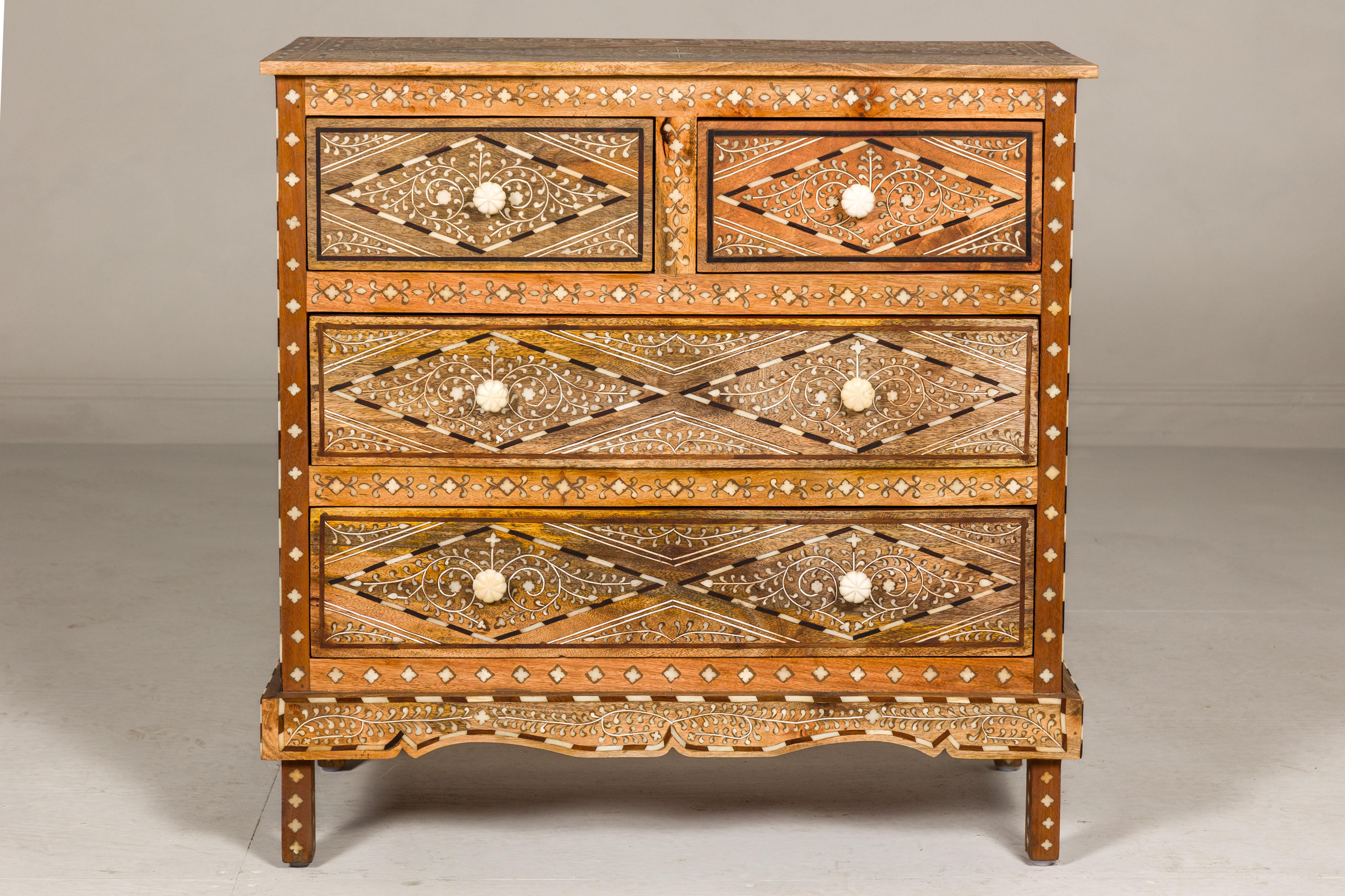 An Anglo-Indian style four-drawer chest with foliage-themed bone inlaid décor. With a design as intricate as a sonnet, this Anglo-Indian style four-drawer chest breathes life into any space it occupies. Crowned by an artfully inlaid top and swathed