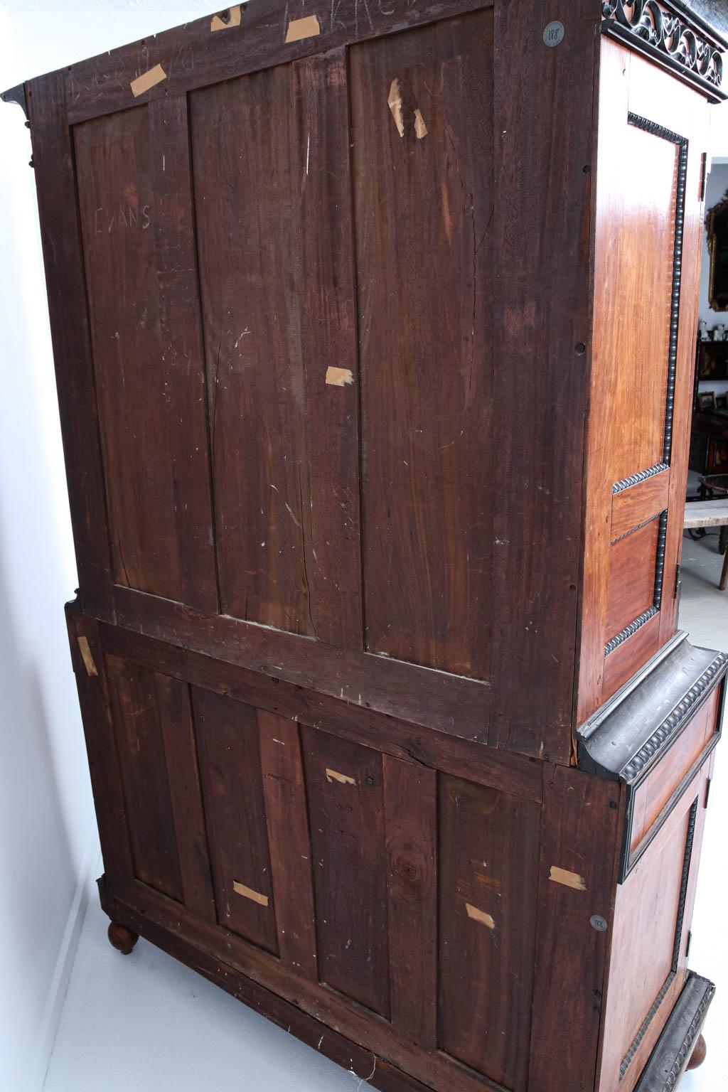 Anglo-Indian style satinwood and ebony cabinet with metal hardware on turned turnip feet. The piece comes with a two-door cabinet over three small drawers and is heavily detailed with scrolled foliage tracery as seen on the bottom skirt and