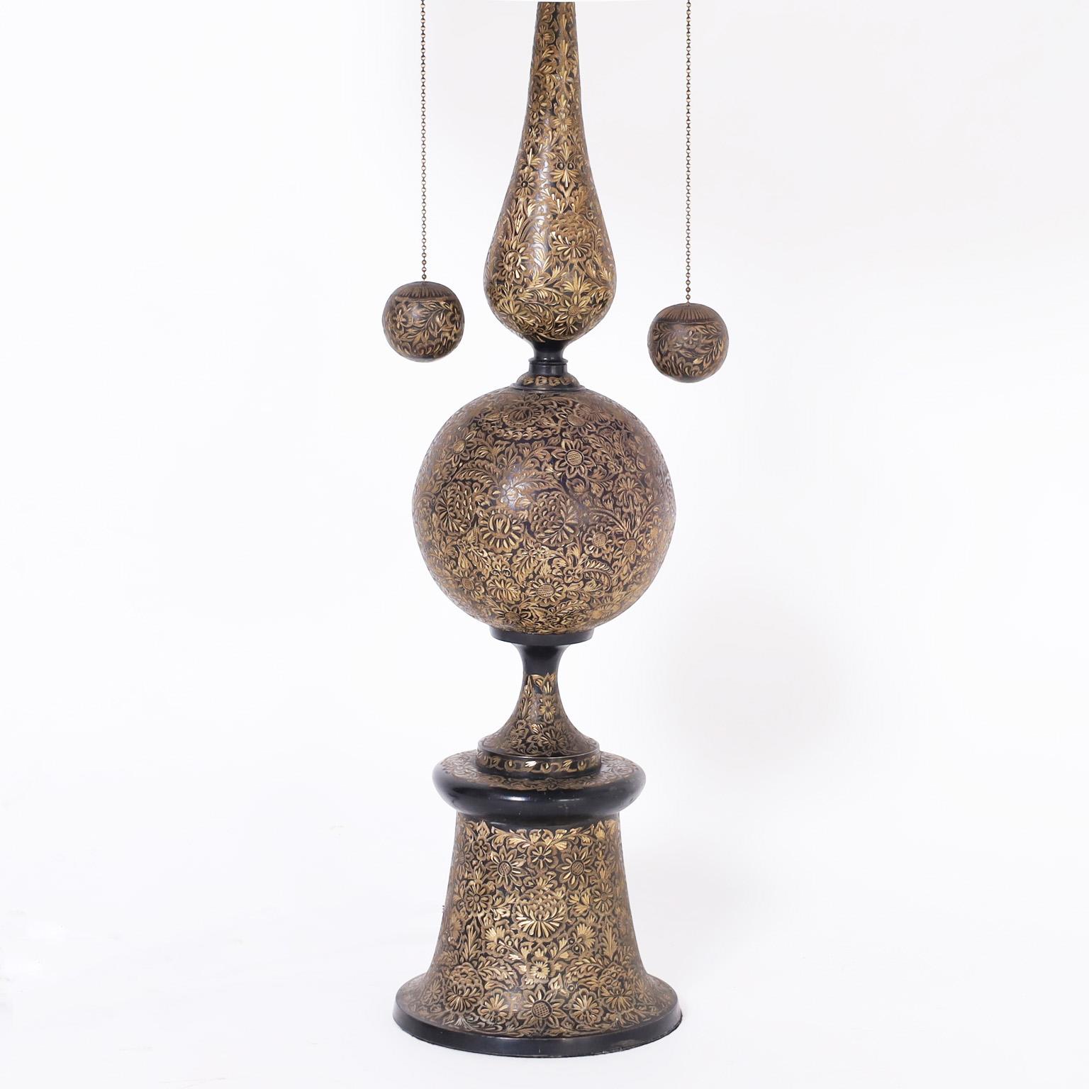 Chic Indo modern table lamp crafted in brass featuring an exotic form with an ebonized finish ambitiously hand etched with elaborate floral designs.
