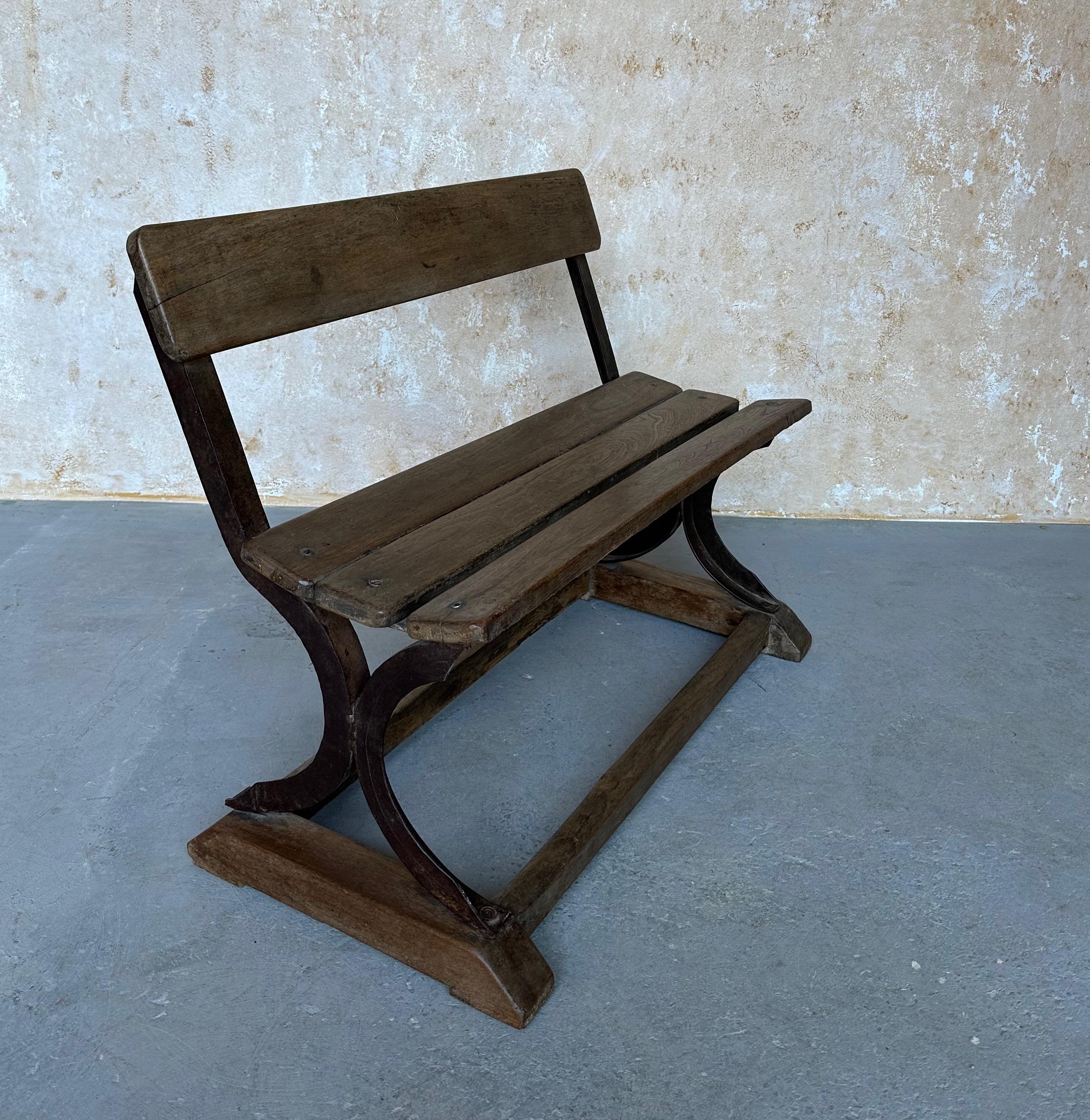 A very unusual small scaled wood and iron bench. Add a unique touch to any space with this vintage wood and iron bench. Boasting a beautiful aged patina, this early 20th century piece is sure to draw attention in any area. While it may have