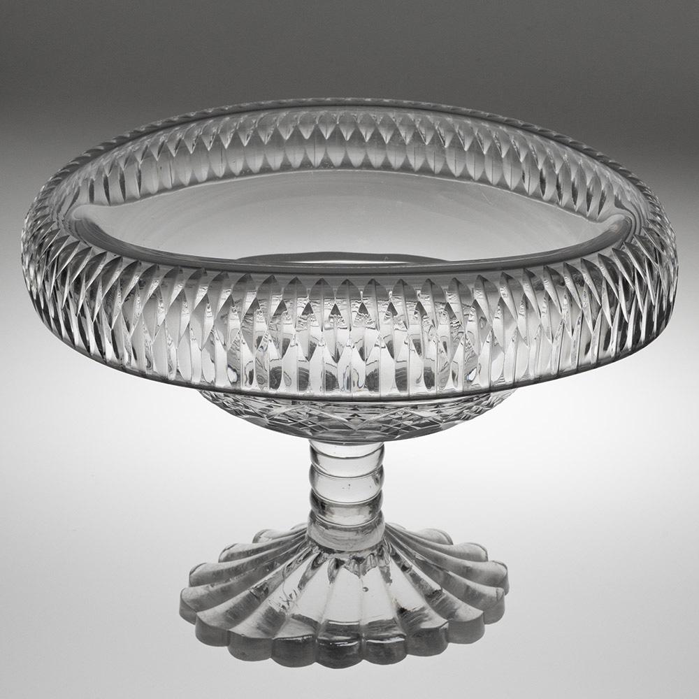 Heading :  Anglo-Irish glass bowl with fold over rim
Period :  George III
Origin :   Ireland – most likely cork
Colour :  Clear
Bowl :  Fold over rim with a band of split cuts to the rim and a band of diamonds to dthe body.
Stem :   Bobbin
Foot : 