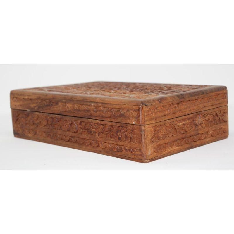 Hand carved large wooden Anglo-Raj jewelry box.
Early 20th century wood box richly decorated overall with arabesques and floral carving.
Hinged lid shallow relief carving with interior lined with blue velvet.
Islamic Folk Art from