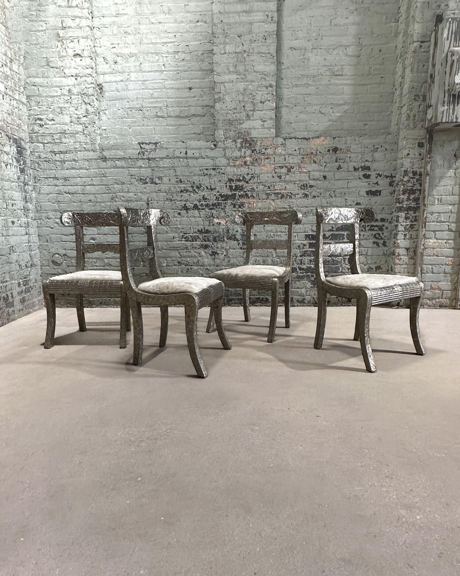 Anglo Raj Style-Indian Hammered Silver Wrapped Clad Dining Chairs w/Hair on Hide 1950's Chairs have been reupholstered. Beautiful detailing to the silver wrapping. Set of Indian chairs adorned with intricate silver metal cladding.
Measure 34
