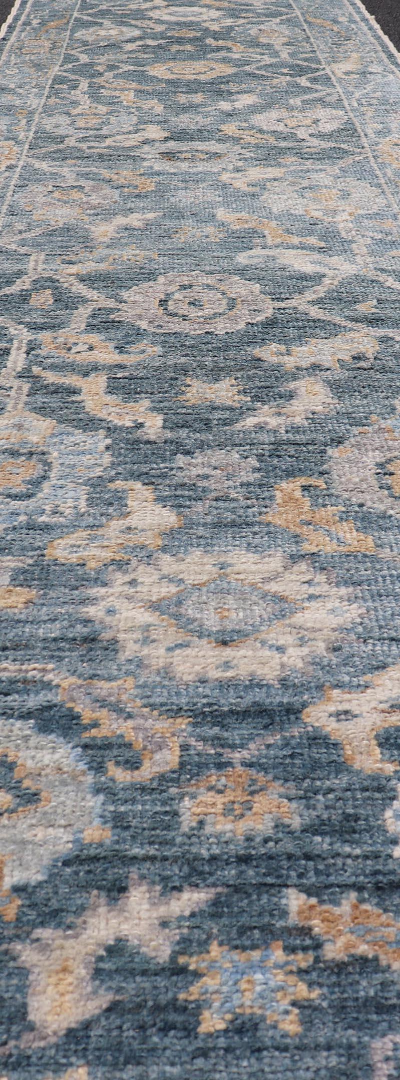 The field portrays a Oushak floral design in cream, light blue, cream and tan. The background is rendered in a rich dark blue .The border design in this piece is a leaflet-motif design in same colors. 

Measures; 2'7 x 13'3 

Keivan Woven Arts
