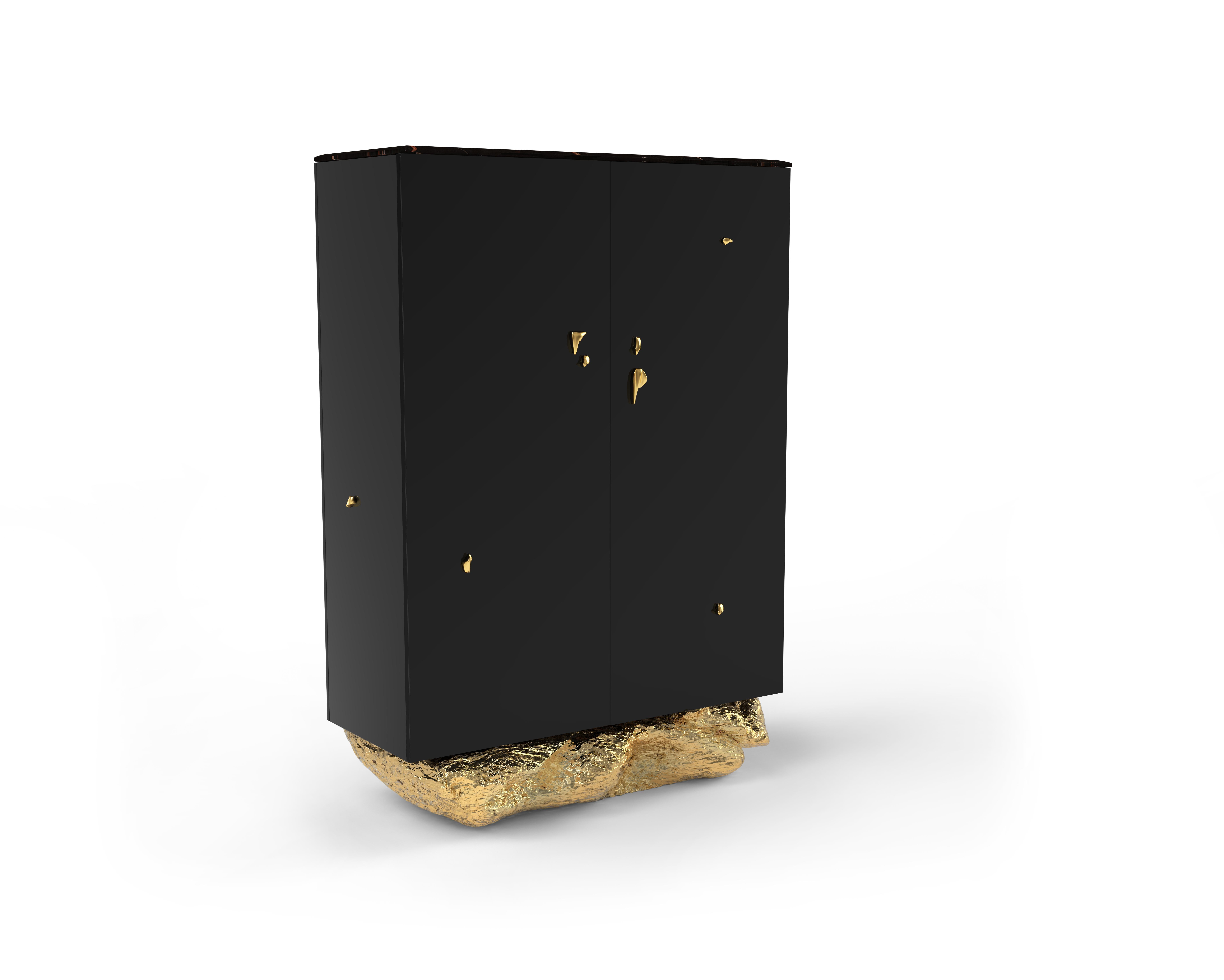 Der Angra-Schrank ist eine exquisite Verschmelzung von Ästhetik und Funktionalität. Dieser Schrank thront elegant auf einem unverwechselbaren, geschwungenen goldenen Sockel, der an die faszinierenden Klippen von Angra do Heroismo auf den