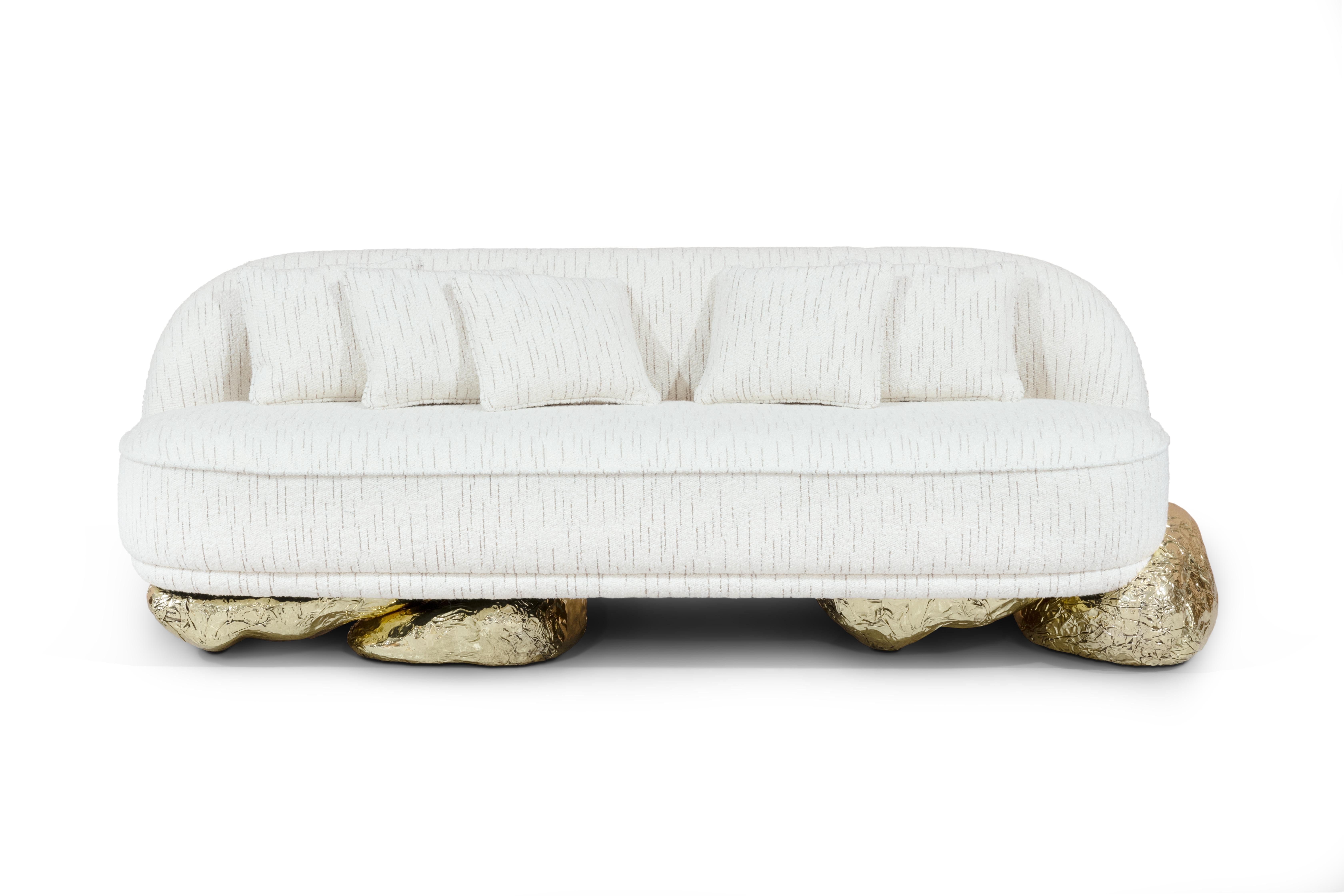 Das Sofa Angra ist eine Mischung aus Kunst und Komfort, inspiriert durch das bemerkenswerte Sideboard Angra. Dieses Sofa ruht elegant auf einem einzigartigen geschwungenen goldenen Sockel, der von den atemberaubenden Klippen von Angra do Heroismo