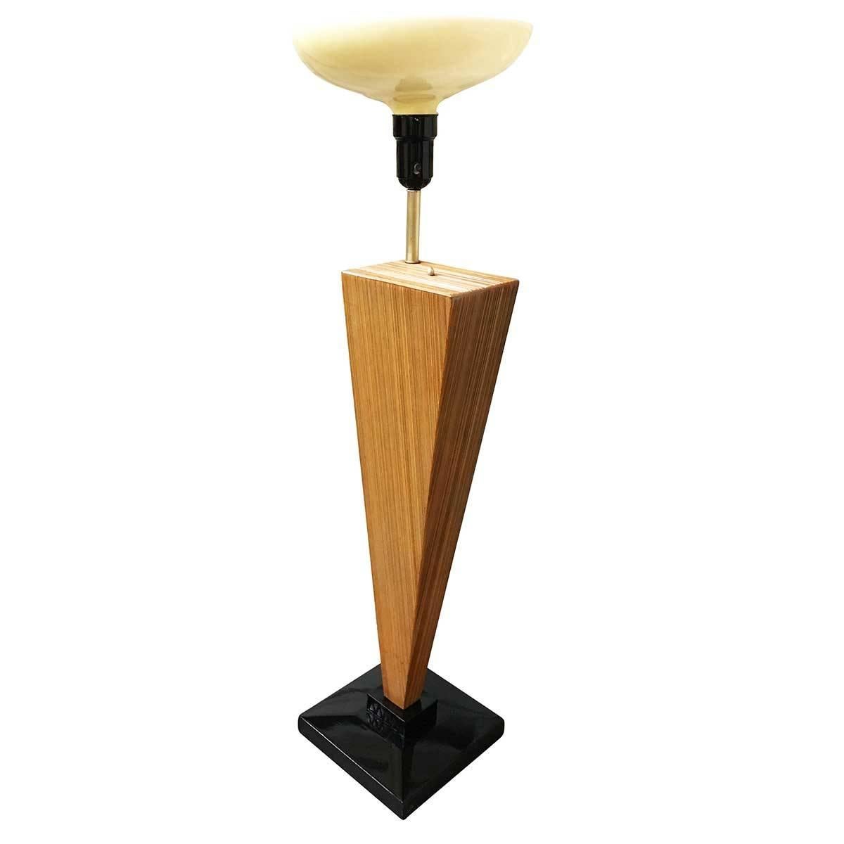 This angular combed wood floor lamp was designed in the style of Paul Frankl, famous for his iconic combed wood furniture pieces designed in the Mid-Century. The lamp has a gloss black lacquer base and comes with a torchiere style glass shade. The