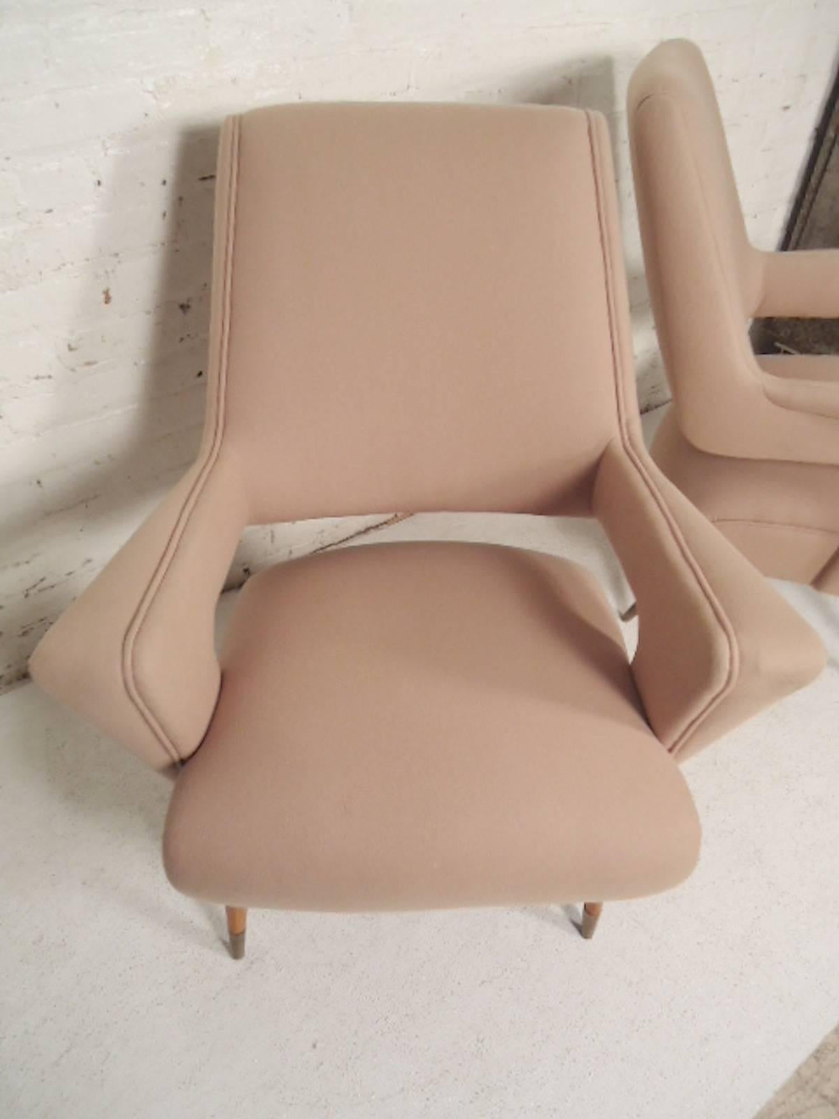 Beautifully designed midcentury style arm chairs. Great shape with open arms and back, giving a floating look. Finished with tapered wood legs and brass caps.

(Please confirm item location - NY or NJ - with dealer).
 