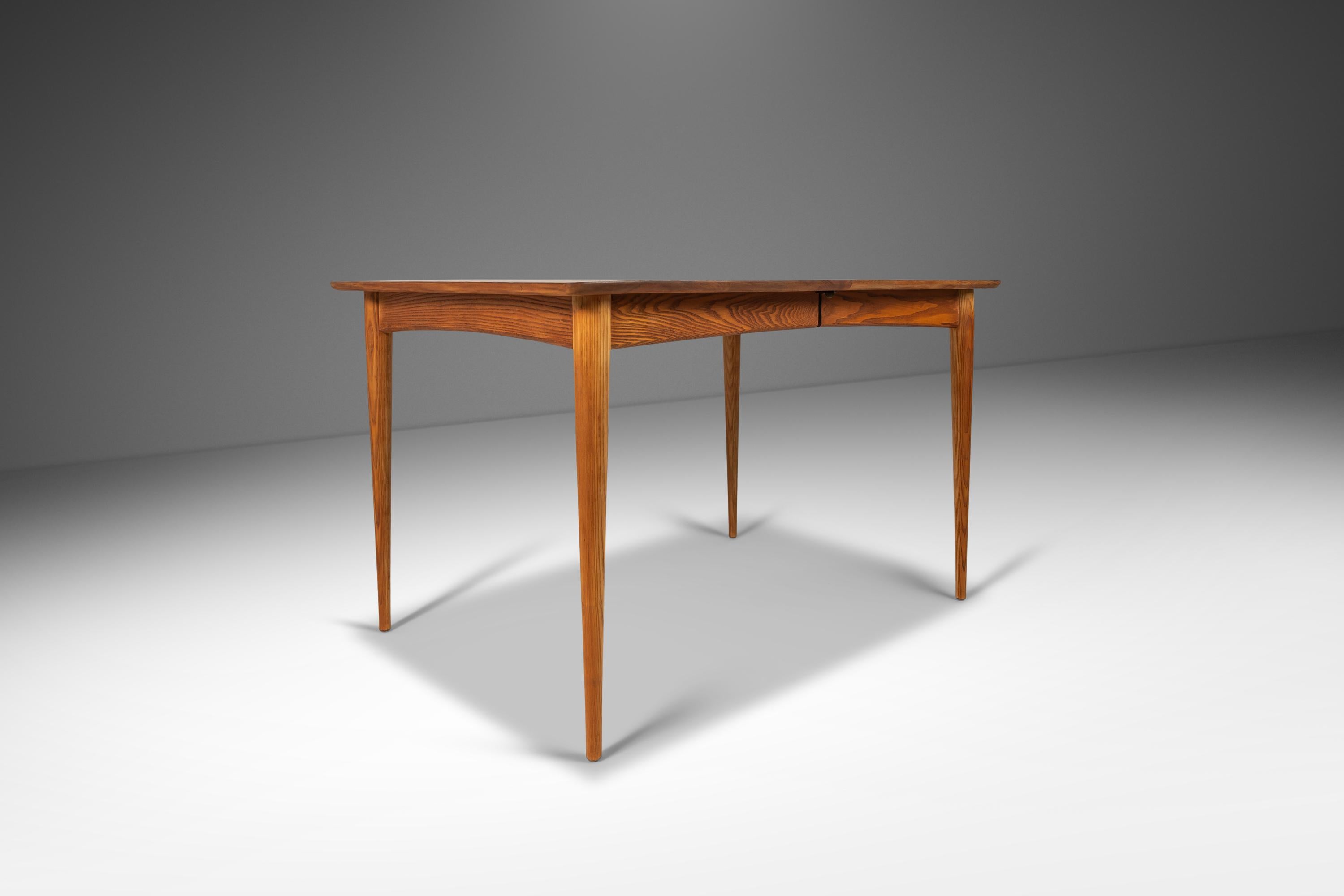 This splendid little dining table is a prime example of American Mid-Century Modern design. Constructed entirely from solid oak with gorgeous, profound woodgrains this exceptional table is altogether warm and charming yet modern and Minimalist in