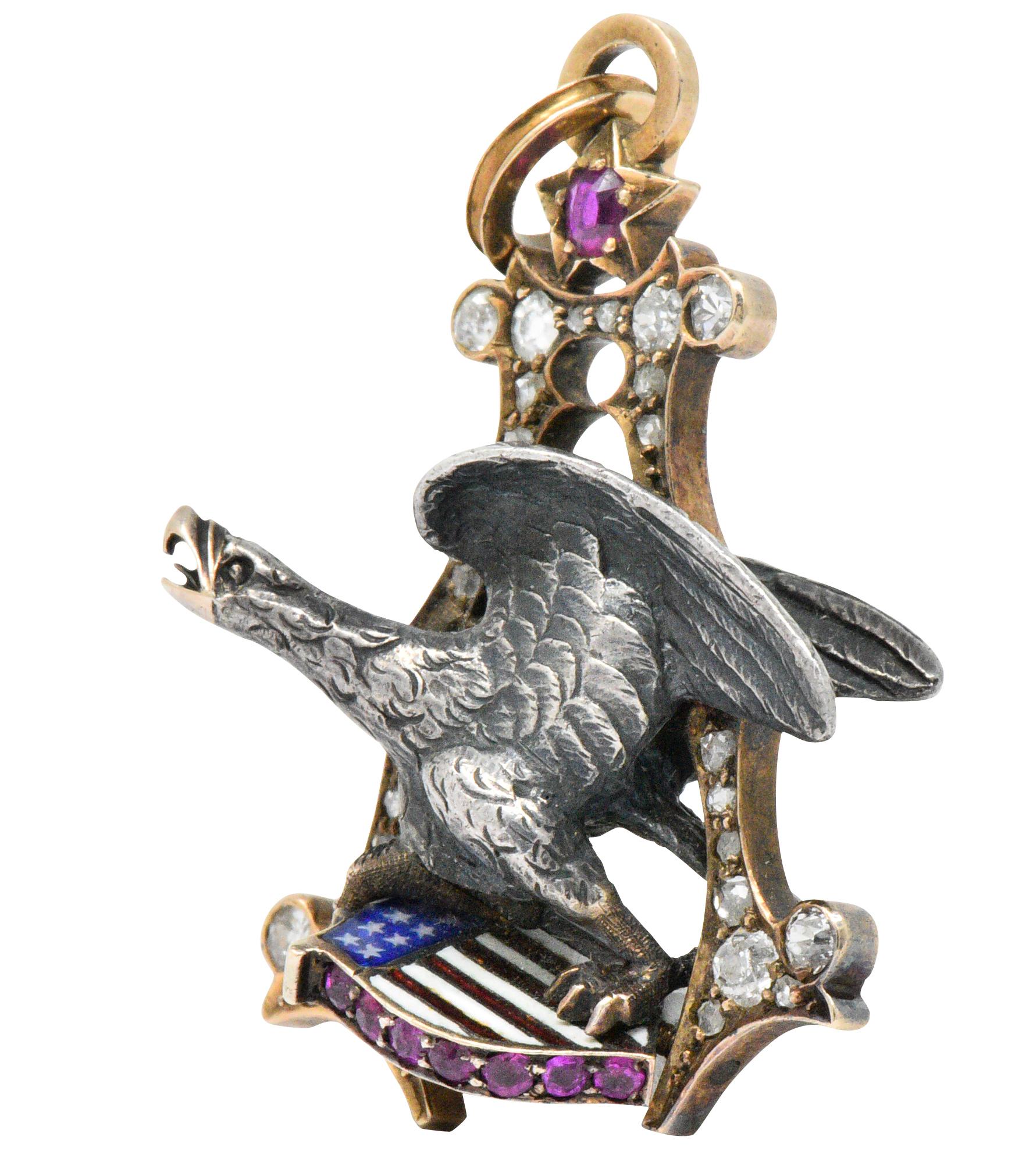Designed as a demential silver eagle clutching an enamel American flag shield set with round cut rubies within a diamond set letter A

Round cut rubies set along the shield with a ruby set star, approximately 0.30 carats total, bright slightly