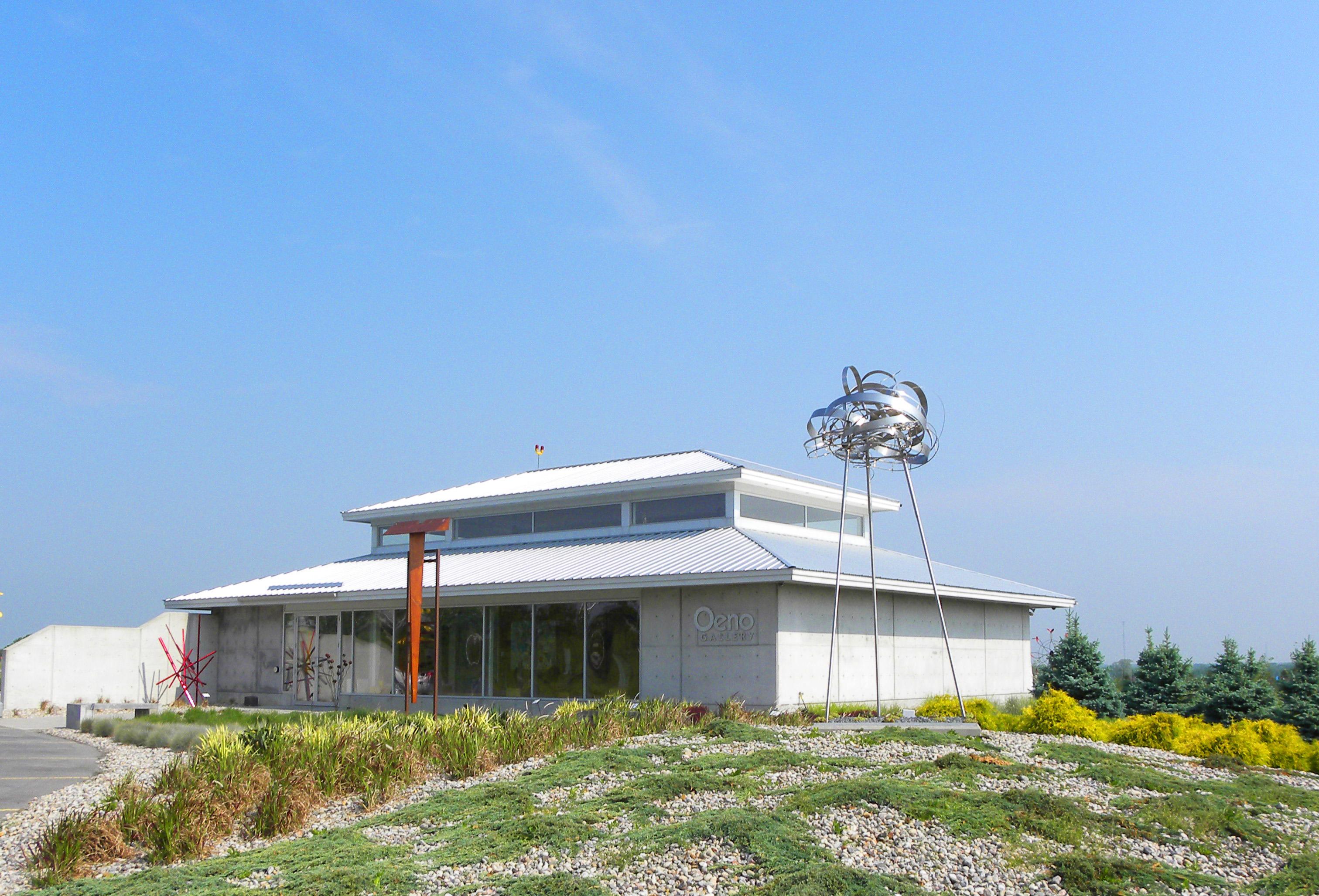 This sculpture is made of stainless steel strips and ribbons that are suspended as part of a changing environment. The form is visible from all sides and with the help of nature: sun and wind, will shine and shimmer. This luminescent form will