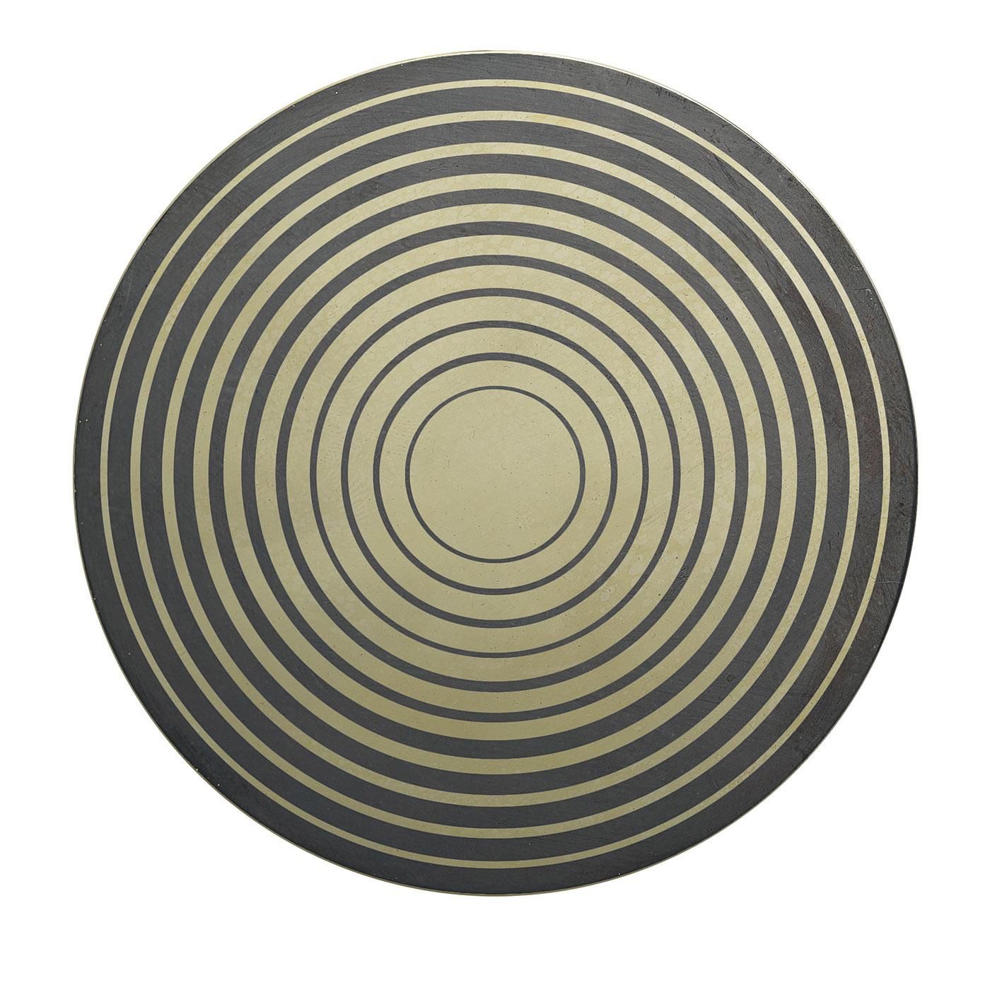Oxides and enamels are cleverly combined to lend this brass decorative disk its distinguishing and unpredictable geometric design inspired by Aniconism. Evoking kinetic forces, it makes for a spot-on addition to contemporary decors, professional or