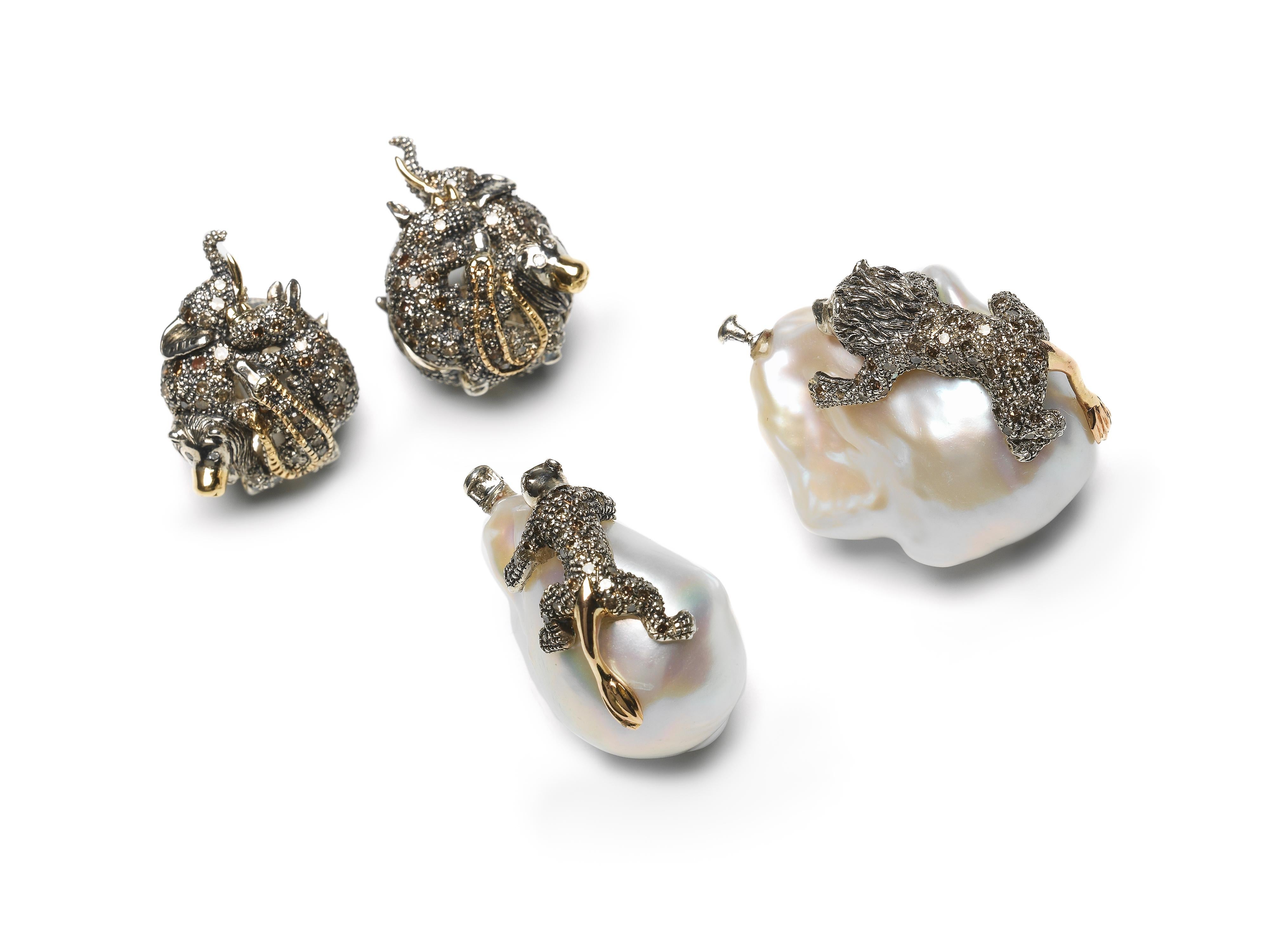 Two beautiful baroque pearls are the focal point of these drop earrings, with the pearls set with animals that appear to crawl up their irregular surface. The animals shown here are male and female lions, but the creatures can be customized to