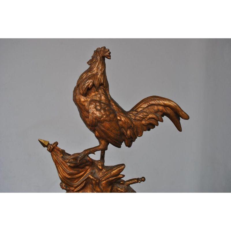 The French Rooster in bronze with golden patina on a green marble base towards the end of the 19th century by Édouard Drouot, with a height of 45 cm. Édouard Drouot was a French sculptor born in Sommevoire on April 3, 1859 and died in Paris on May