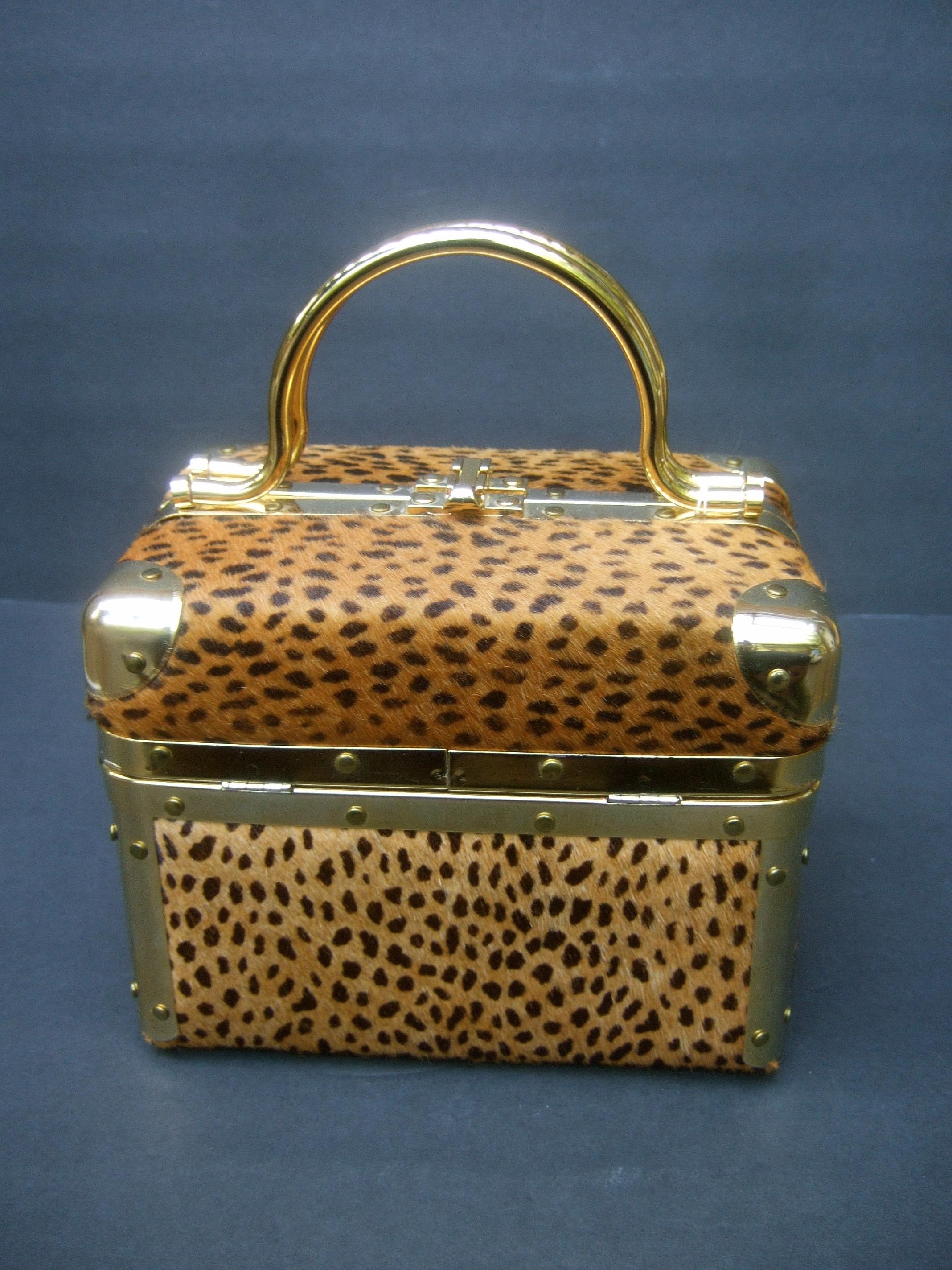 Animal print box purse designed by Lisette New York c 1980s
The stylish handbag is covered with animal print pony fur
Framed with gilt metal hardware; paired with matching gold metal
swivel handles 

The interior is lined in brown taffeta with a