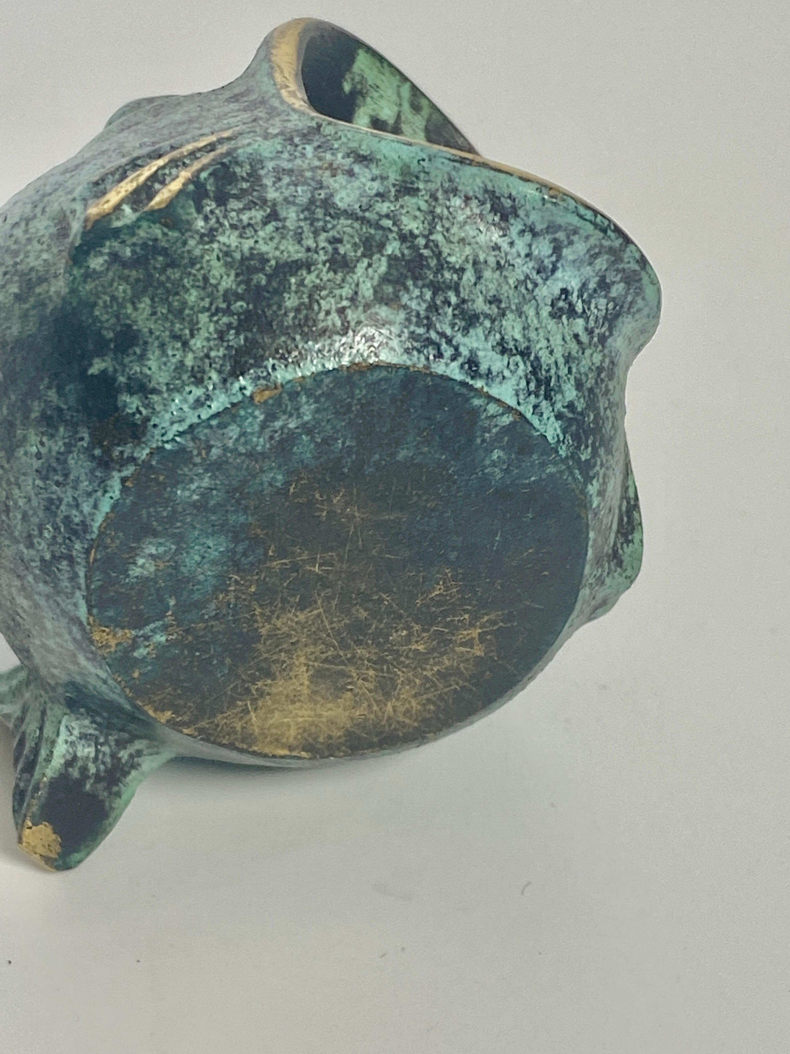 This sculpture, Ashtray, by Walter Bosse, was made in the United States in the 1960s. It is made of patinated brass, green and gold in color. This model in the shape of a fish, is a sculpture, a rare model of the artist.
 we can see other models