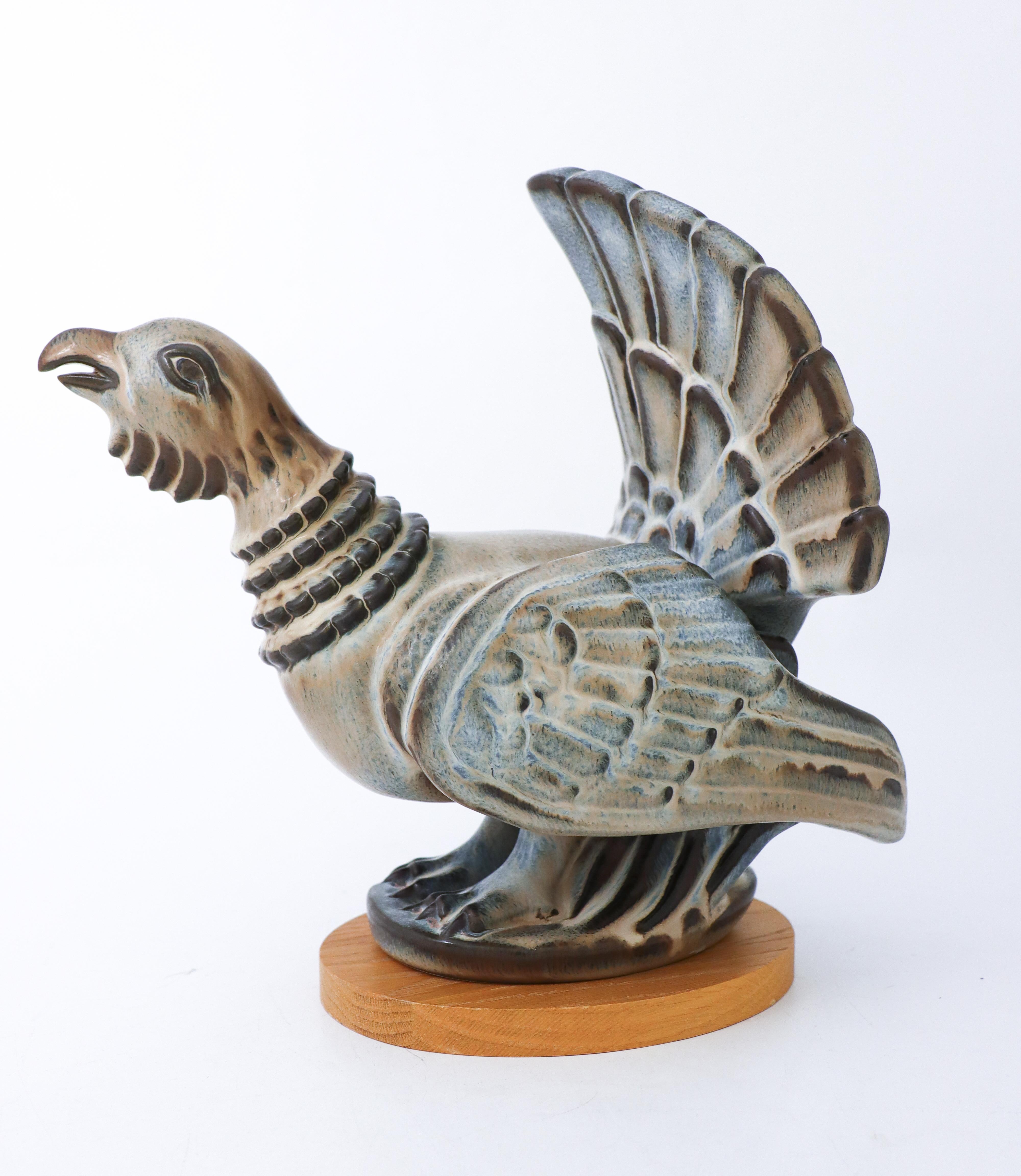 A sculpture of a Capercaillie Bird in ceramic designed by Gunnar Nylund at Rörstrand. It is 32 x 18.5 cm (12.8
