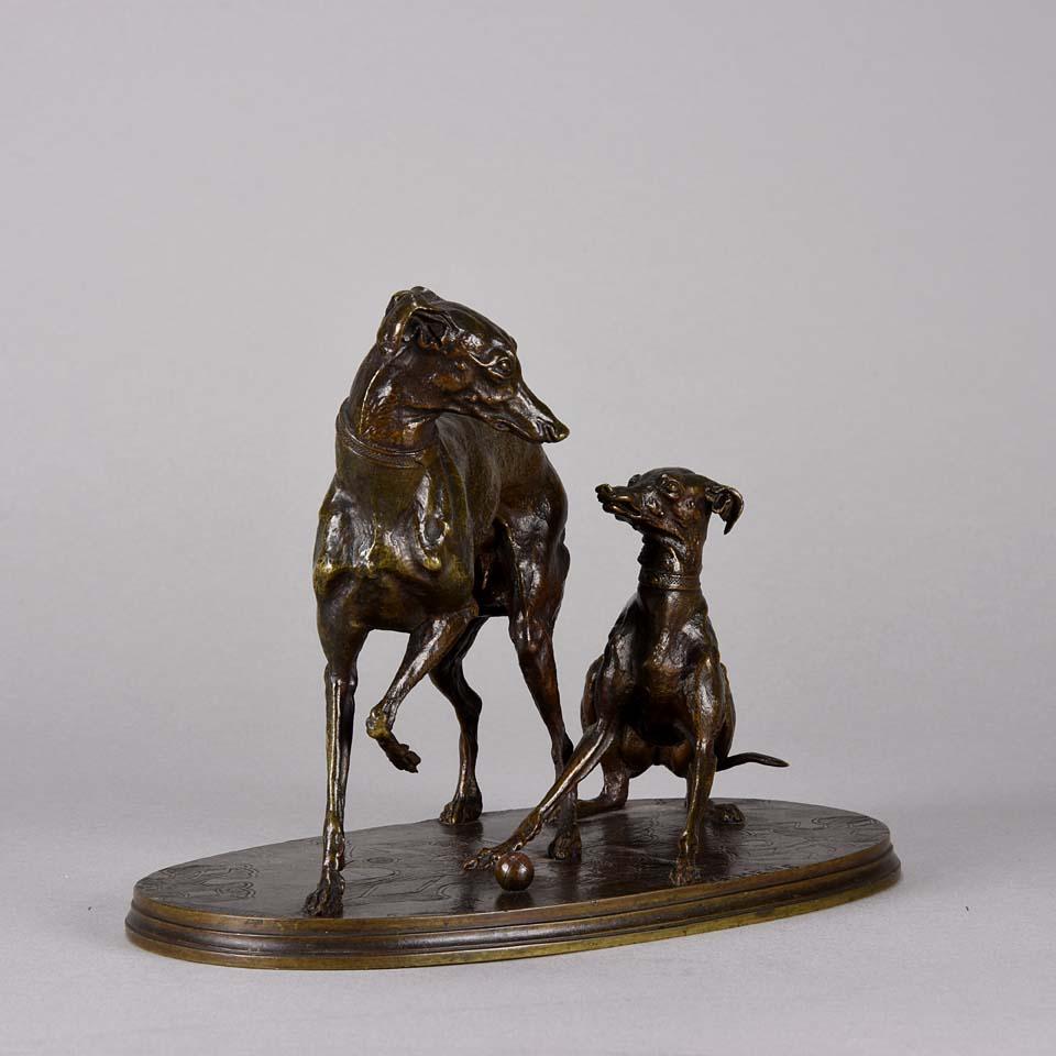 A delightful mid-19th century French animalier bronze study of two whippets playing with a ball on a naturalistic base representing a rug in an interior. The surface of the bronze with rich brown patination and incredibly detailed surface, signed P