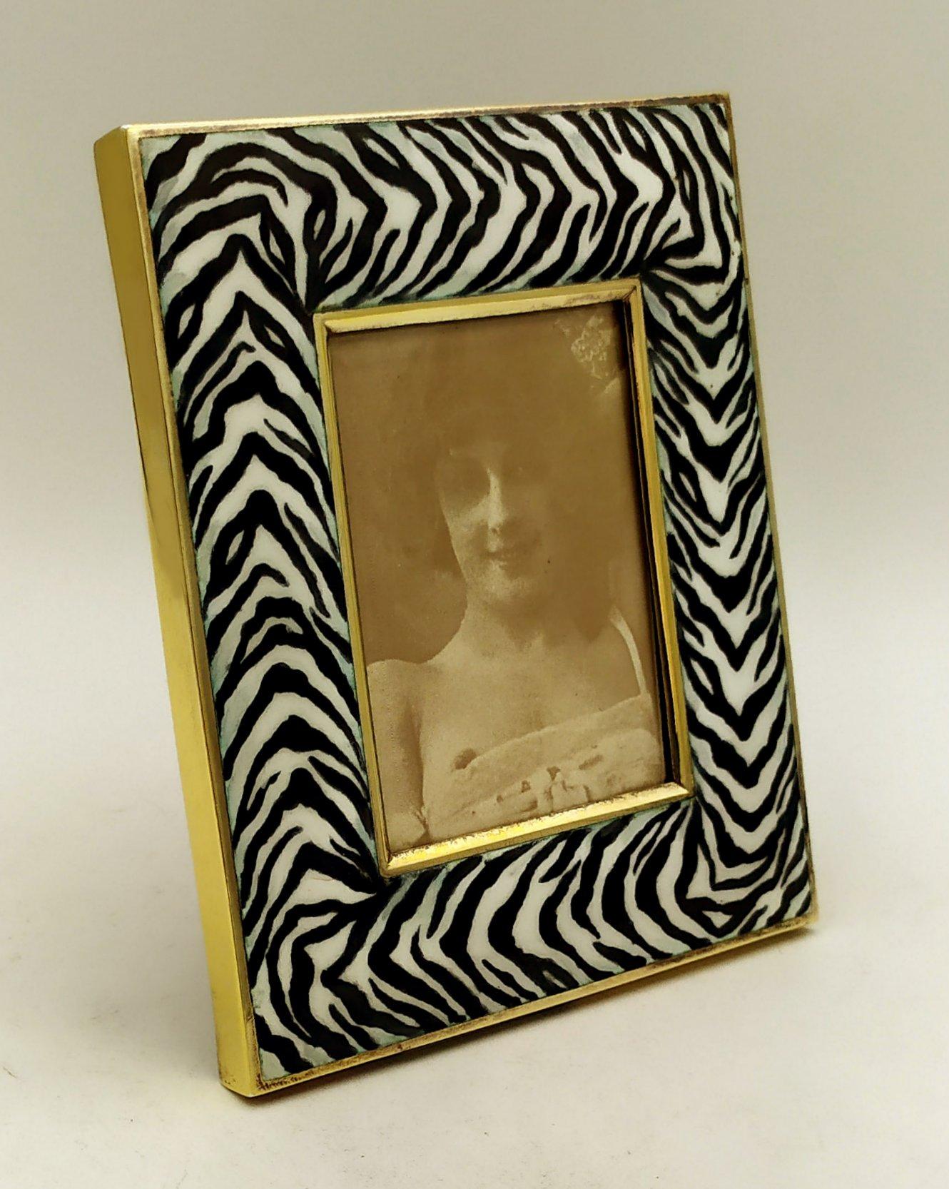 Marco de fotos rectangular de plata de ley 925/1000 dorada con esmalte al fuego, pintado a mano con manchas tipo piel de cebra en un estilo moderno contemporáneo. Medidas exteriores cm. 11 x 12,5 internas cm. 6,5 x 7. Peso gr. 143. Diseñada por