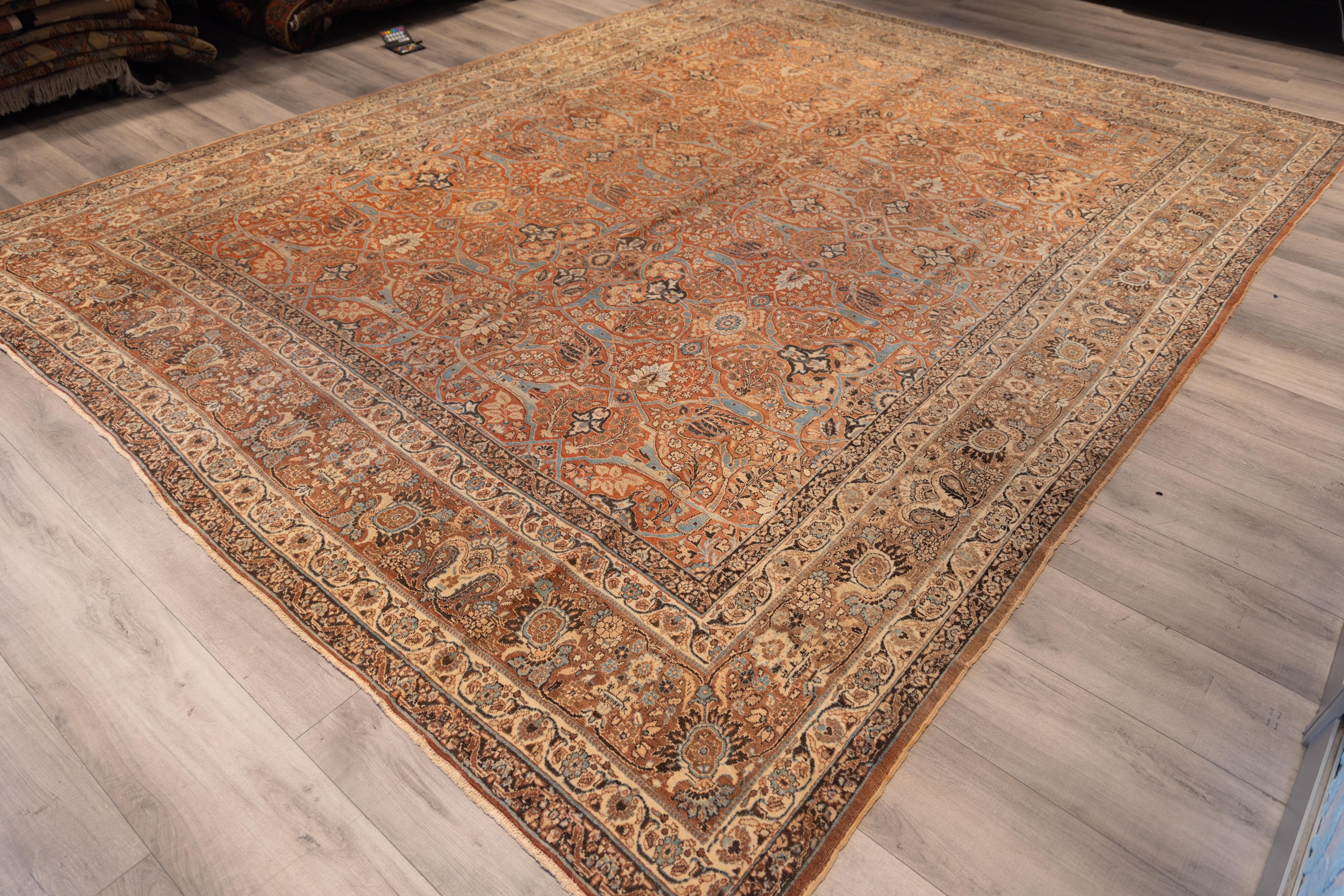 Exquisite Tabriz carpet showcasing  a dense allover herati lattice design rendered in muted coral, ivory, celadon, and soft blues. The field is meticulously filled with stylized palmettes, rosettes, and delicate vinery in a rhythmic repeat.

The