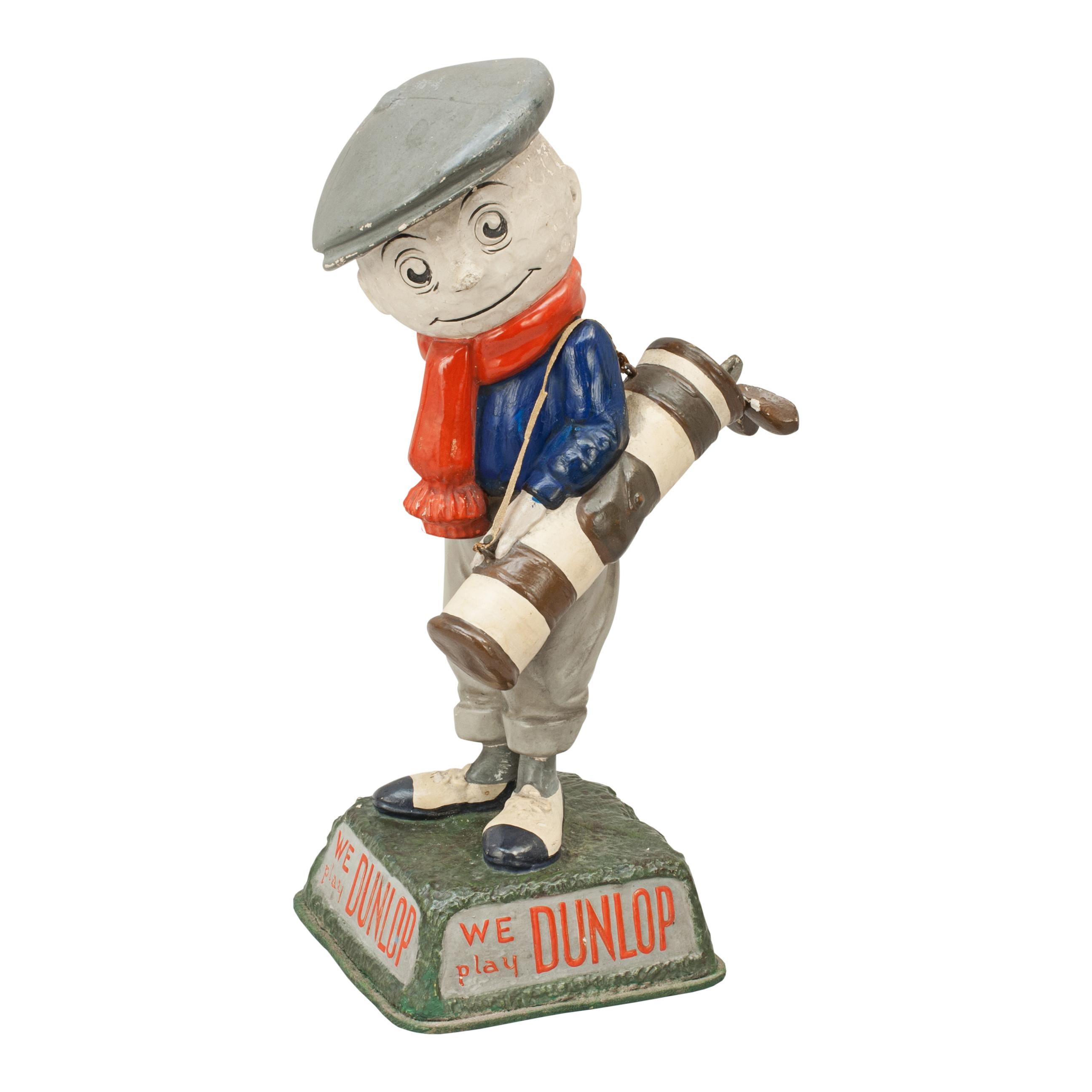 Antique advertising Dunlop man.
A colorful advertising golf figure in the form of a caddie with a golf ball head and constructed from plaster of Paris. The base has the slogan in relief: 