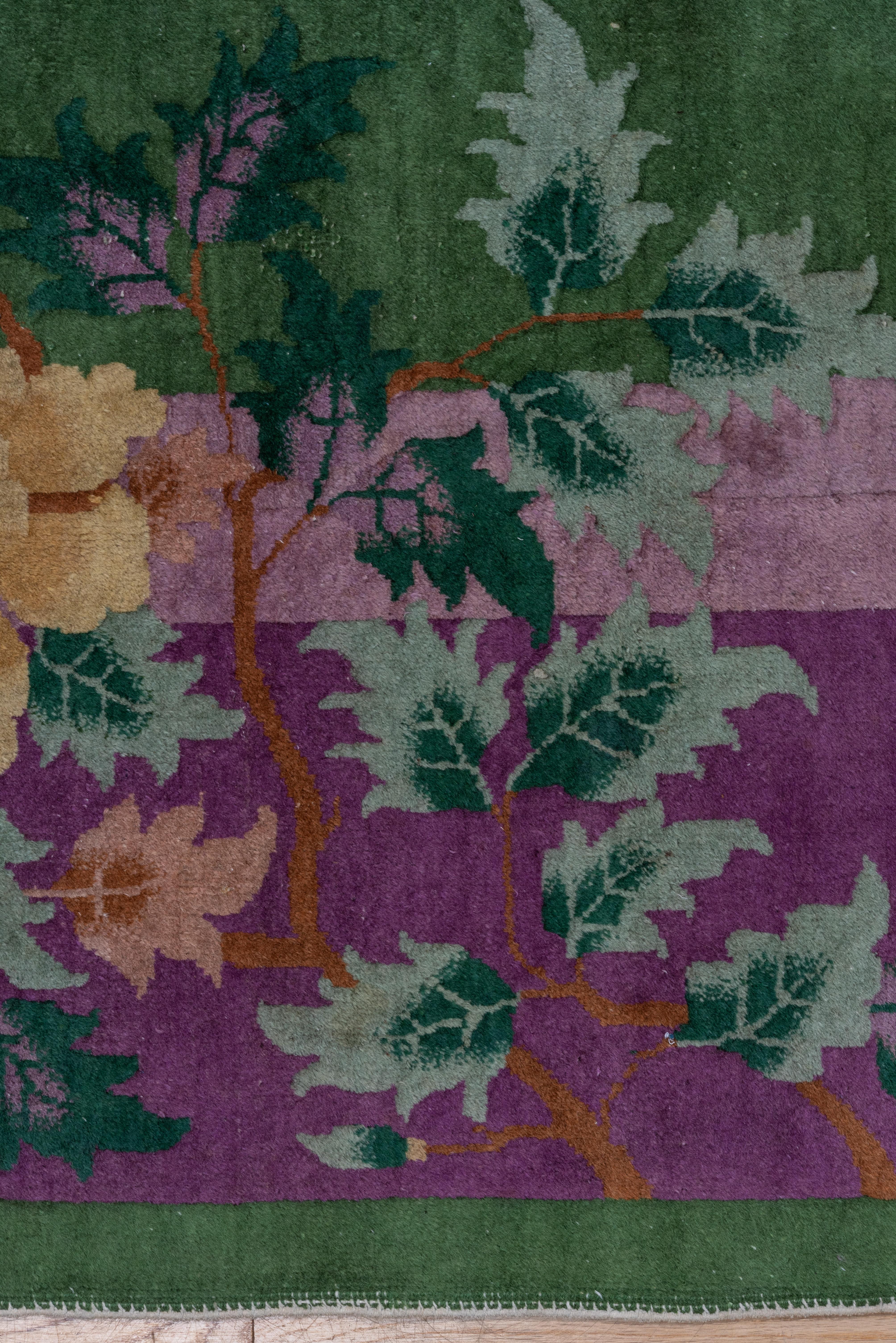A crane soars above in the green field with flower-filled porcelain vases and loose seasonal blossoms below. Purple main border, lavender secondary border. with decorative rocks, paeonies and other flowers passing into the field, a 1920s Chinese