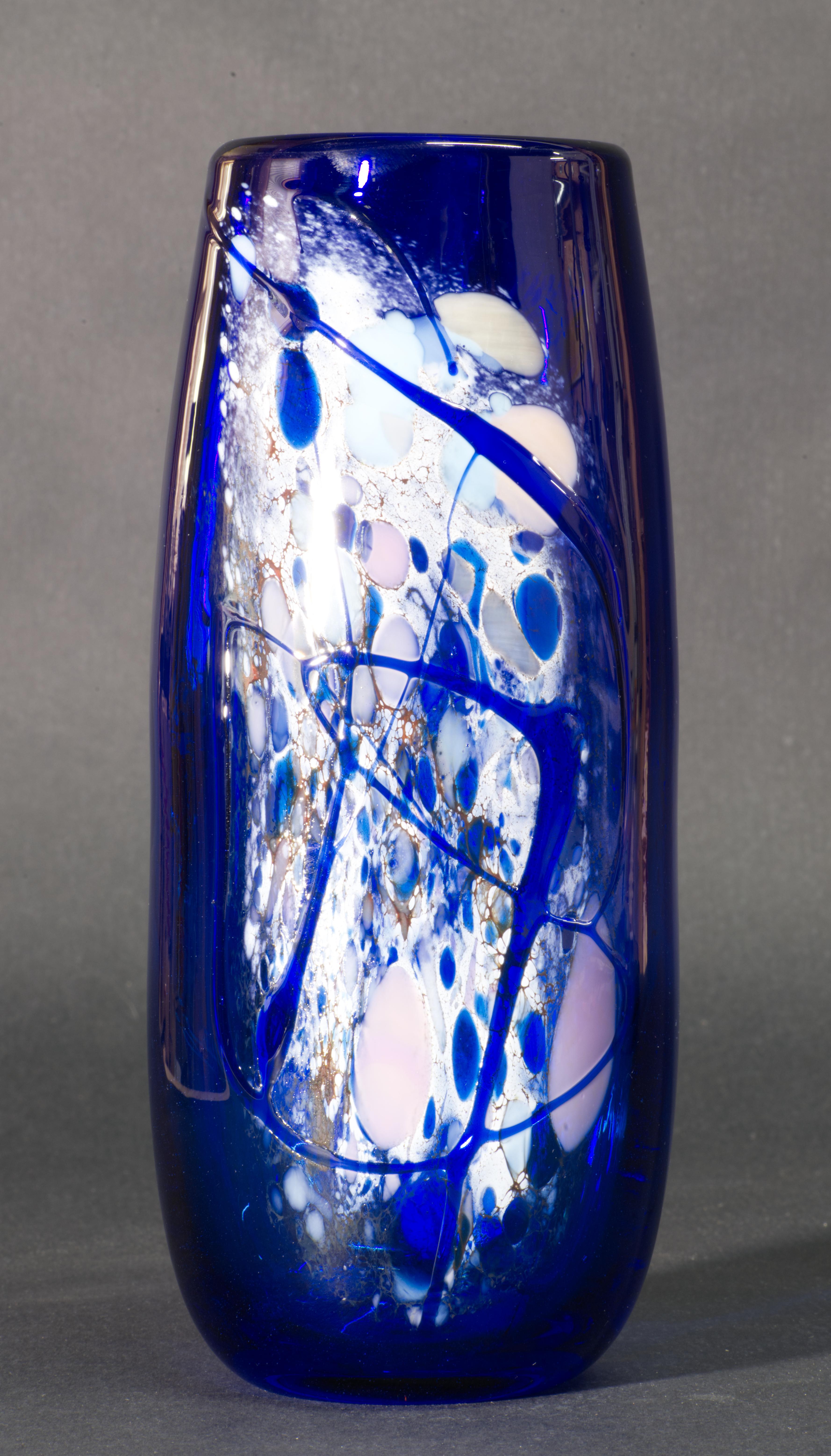  Le vase en verre bleu cobalt a été conçu et soufflé à la main par Ann Concoran pour le studio Nourot Glass. Le vase est décoré d'un motif abstrait multicolore en verre fusionné sur l'avant et l'arrière du vase. Elle est signée et datée à