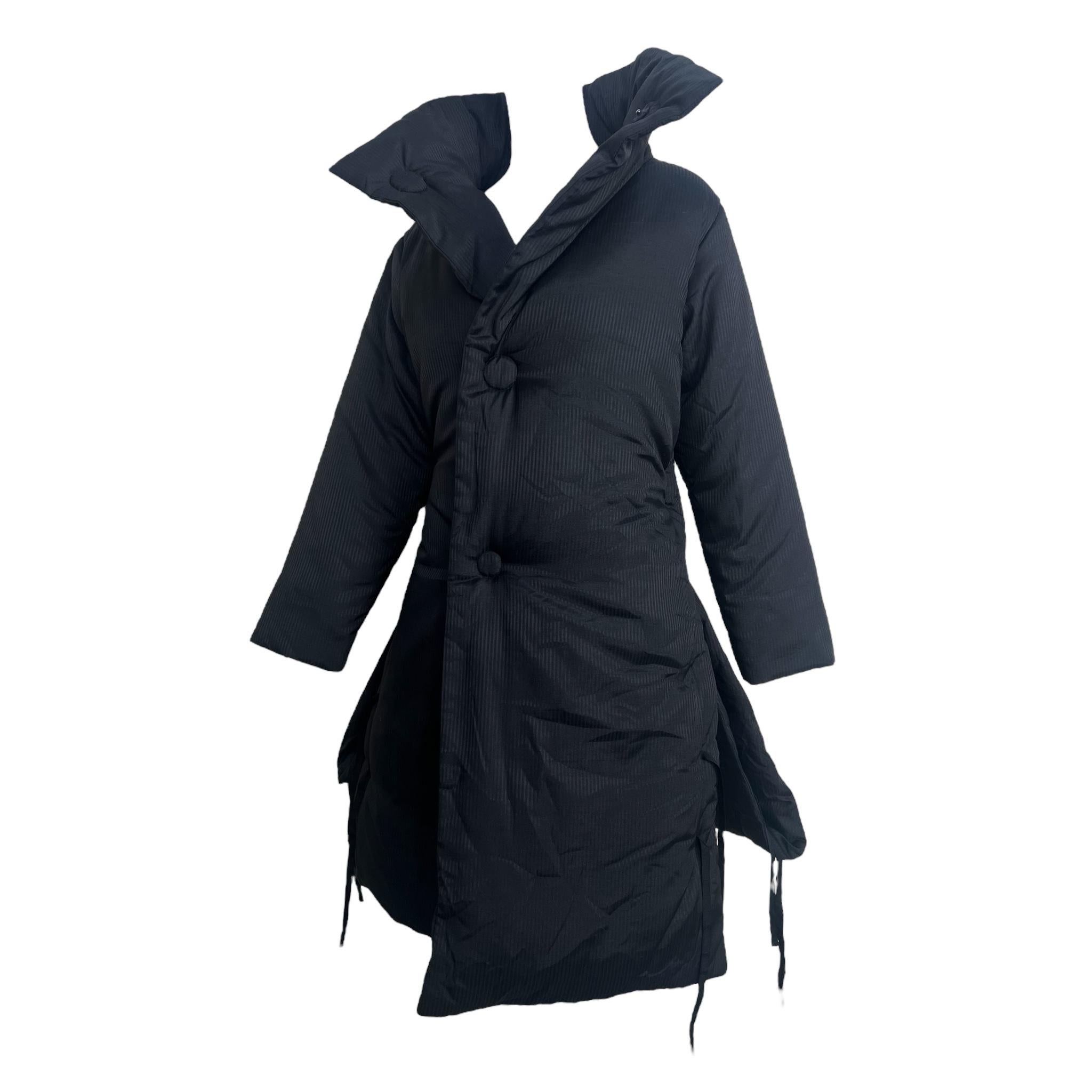 Ann Demeulemeester 1990, cappotto in cotone gessato nero con piuma d'oca: uno squisito esempio di capospalla d'avanguardia del maestro belga del design decostruito. Questo innovativo puffer presenta un colletto a ventaglio con un bottone che scatta