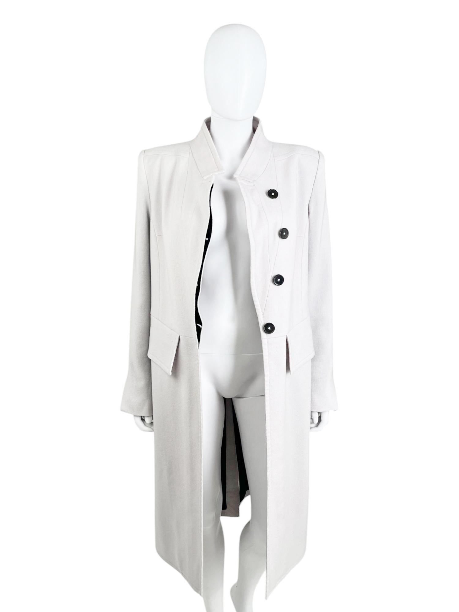 - Designed by Ann Demeulemeester
- 2000's period
- Ecru asymmetric coat
- Frontal hidden asymmetric button closure
- High neckline
- Two frontal pockets
- Bell sleeves
- Made in Italy
- Very good condition
- Materials: Wool and Cotton
- Size: IT 40 