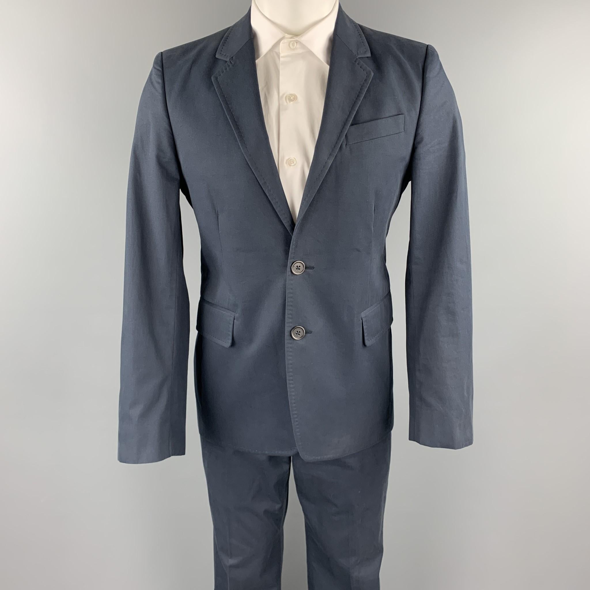 ANN DEMEULEMEESTER suit comes in a navy cotton and includes a single breasted, two button sport coat with a notch lapel and matching flat front trousers. Comes with tags. Made in Portugal.

Very Good Pre-Owned Condition.
Marked: