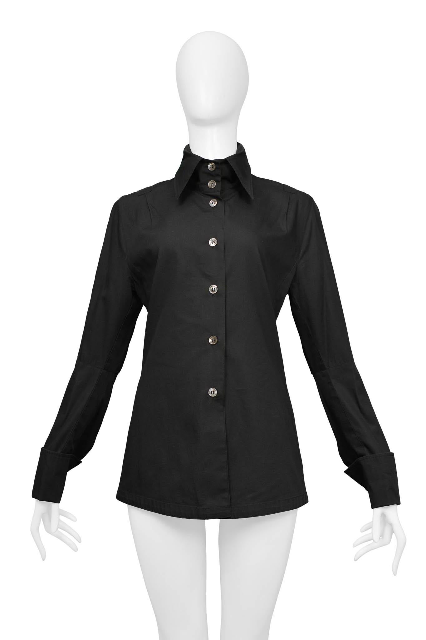 Resurrection Vintage is excited to offer a vintage Ann Demeulemeester black cotton shirt with a center front placket with grey buttons, utility tape trim, extra tall neck panel, and double buttons at the cuffs. 
Ann Demeulemeester
Size 36
Cotton