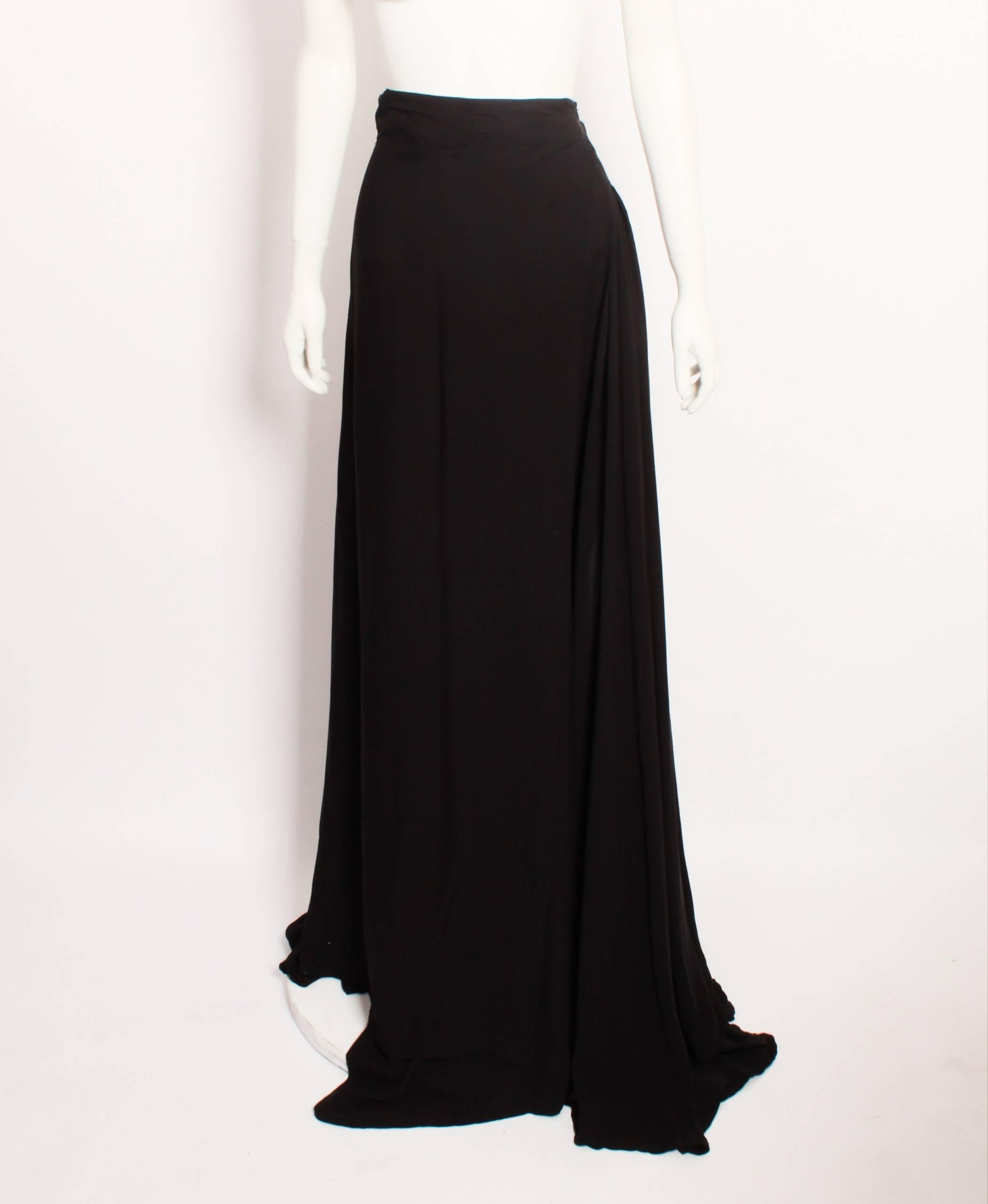Ann Demeulemeester black silk georgette maxi wrap skirt features voluminous full length flared panels with the added fullness of inverted pleated panels.  Fastens with adjustable waist ties.
Made in Belgium. Size 42.