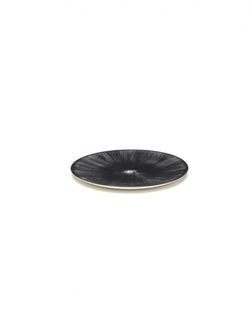 Set of two 14 centimeter Ann Demeulemeester porcelain plates. A black matte glaze on the outside with a glossy off-white glaze on the inside. The contrast between matte and glossy, and also the contrast between black and off-white, are typical of