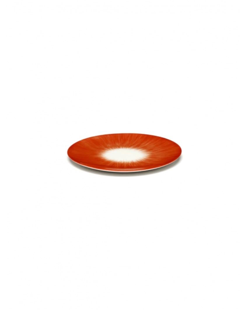 Ann Demeulemeester off-white and red hand-painted porcelain plates in a set of two. A red matte glaze on the outside with a glossy off-white glaze on the inside. The contrast between matte and glossy, but also the contrast of color, are typical of
