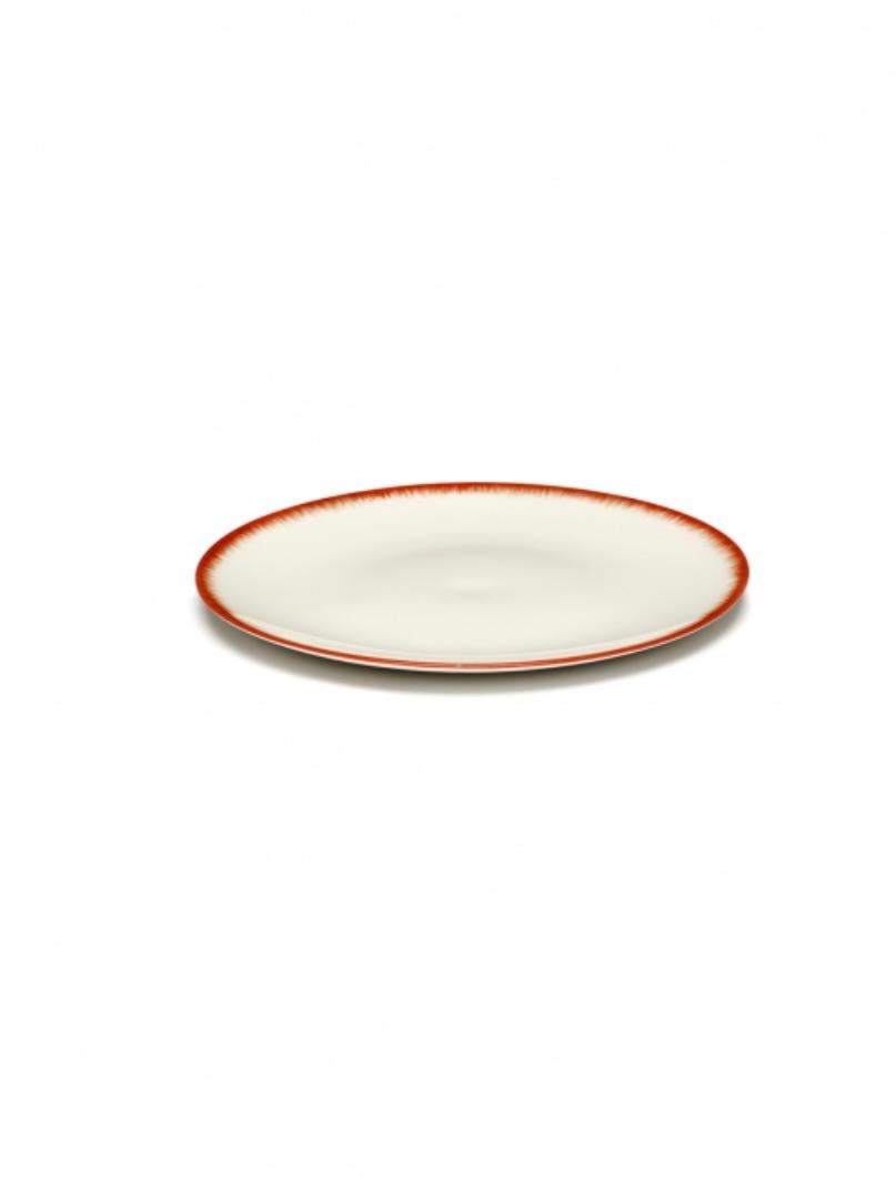 Two 17.5 centimeter hand-painted porcelain plates. A red matte glaze on the outside with a glossy off-white glaze on the inside. The contrast between matte and glossy, but also the contrast in color, are typical of the Ann Demeulemeester style.