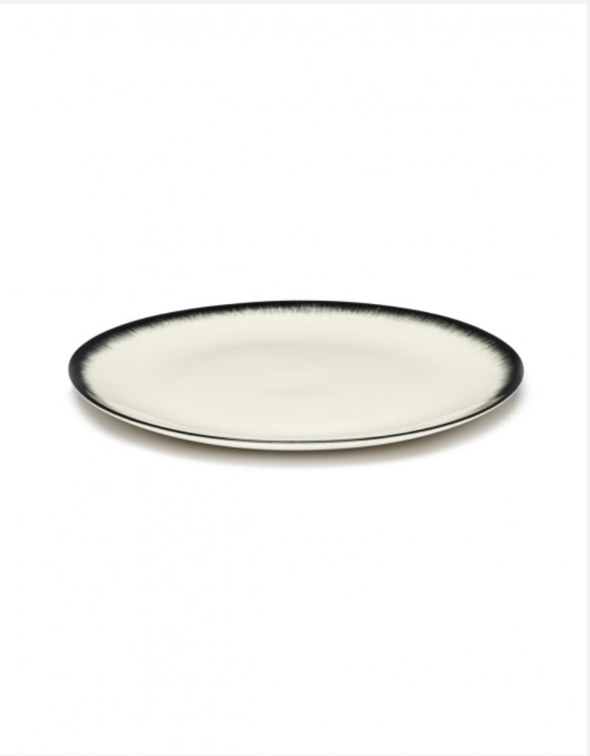 Set of two Ann Demeulemeester hand-painted porcelain plates. A black matte glaze on the outside with a glossy off-white glaze on the inside. The contrast between matte and glossy, but also the contrast between black and off-white, are typical of the