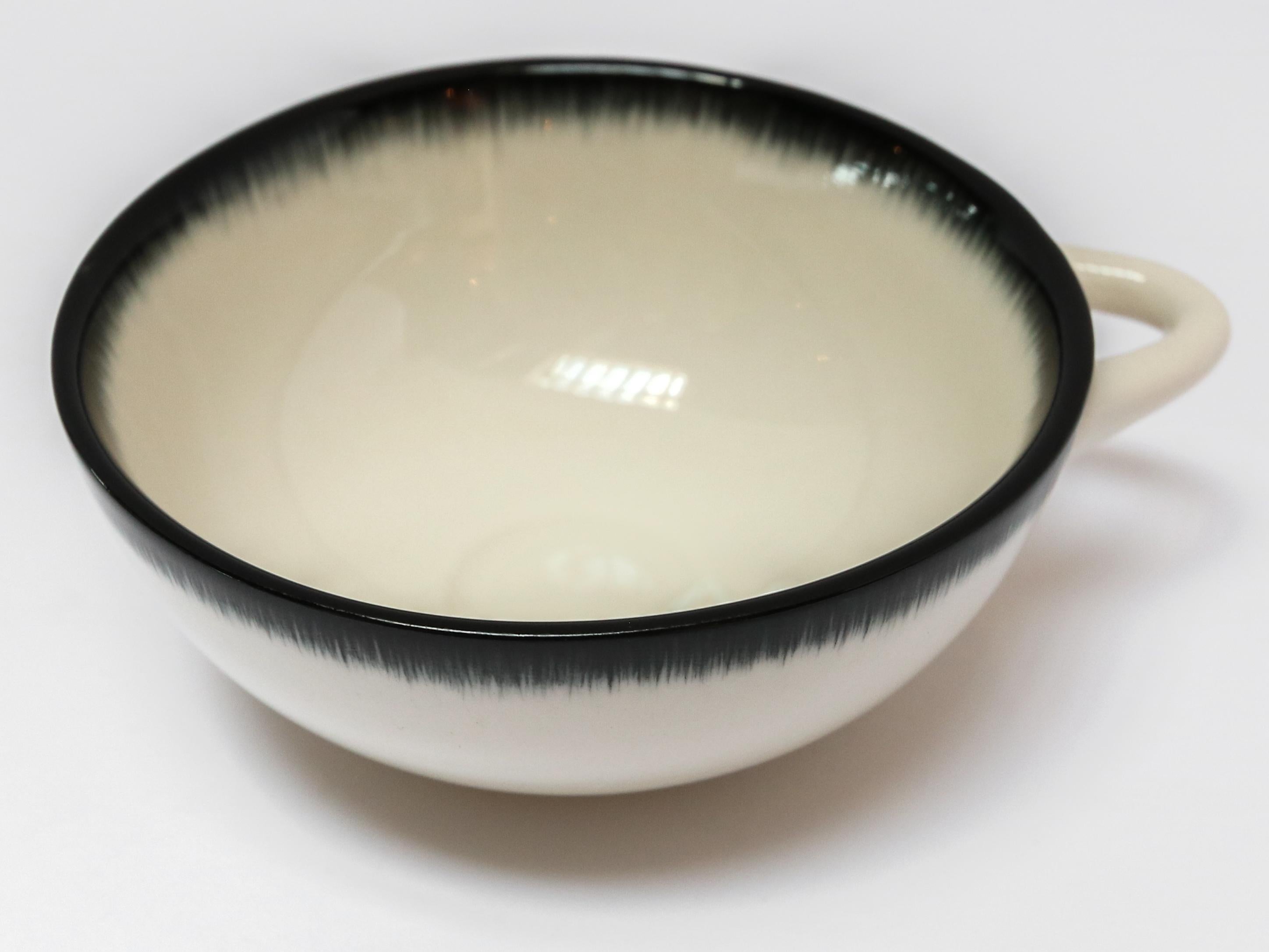 Ann Demeulemeester for Serax Dé espresso cup in off white / black rim. Hand painted with a starburst pattern. 7.8 cm diameter x 3.2 cm high. Must be purchased in quantities of two.