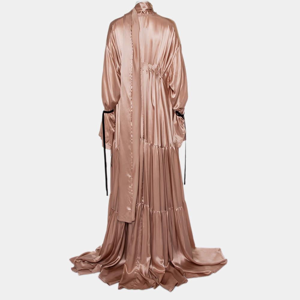 This dreamy Ann Demeulemeester maxi dress will immediately transport you to the world of high fashion. The pink silk satin creation has been designed in an oversized tiered silhouette with concealed front button fastenings and long sleeves. The