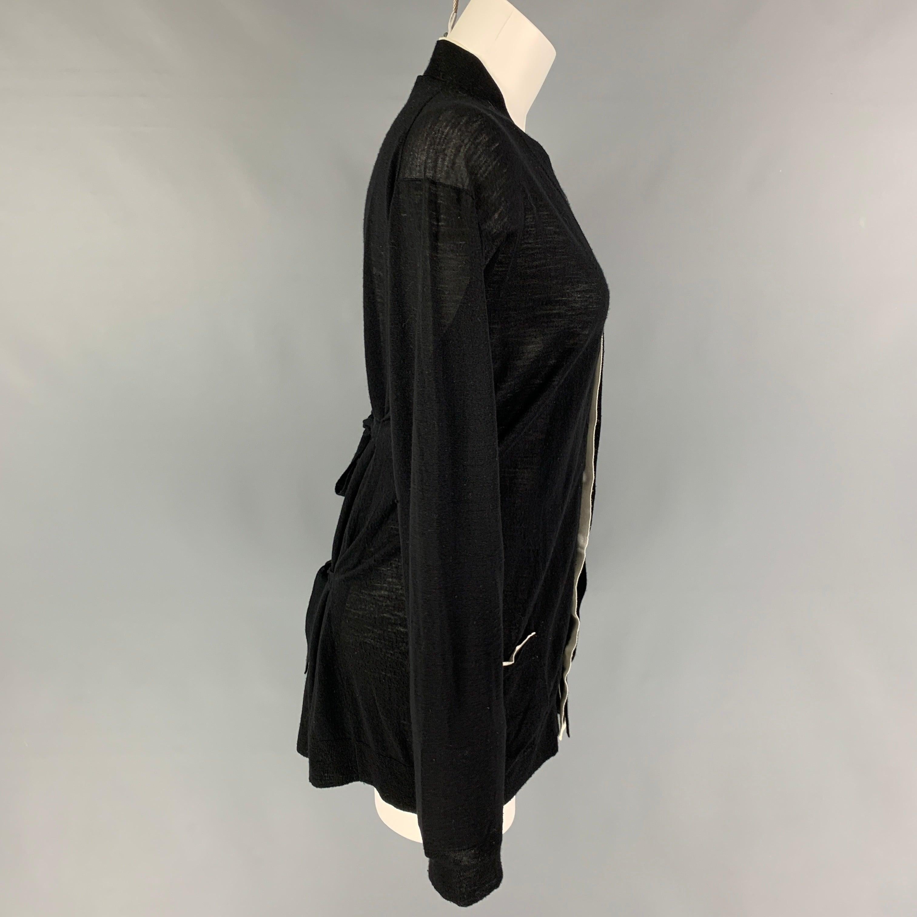 ANN DEMEULEMEESTER cardigan comes in a black wool with a white contrast trim featuring back self-toe details, front pockets, back slit, and a buttoned closure. Made in Belgium.
Very Good
Pre-Owned Condition. 

Marked:   40 

Measurements: 
