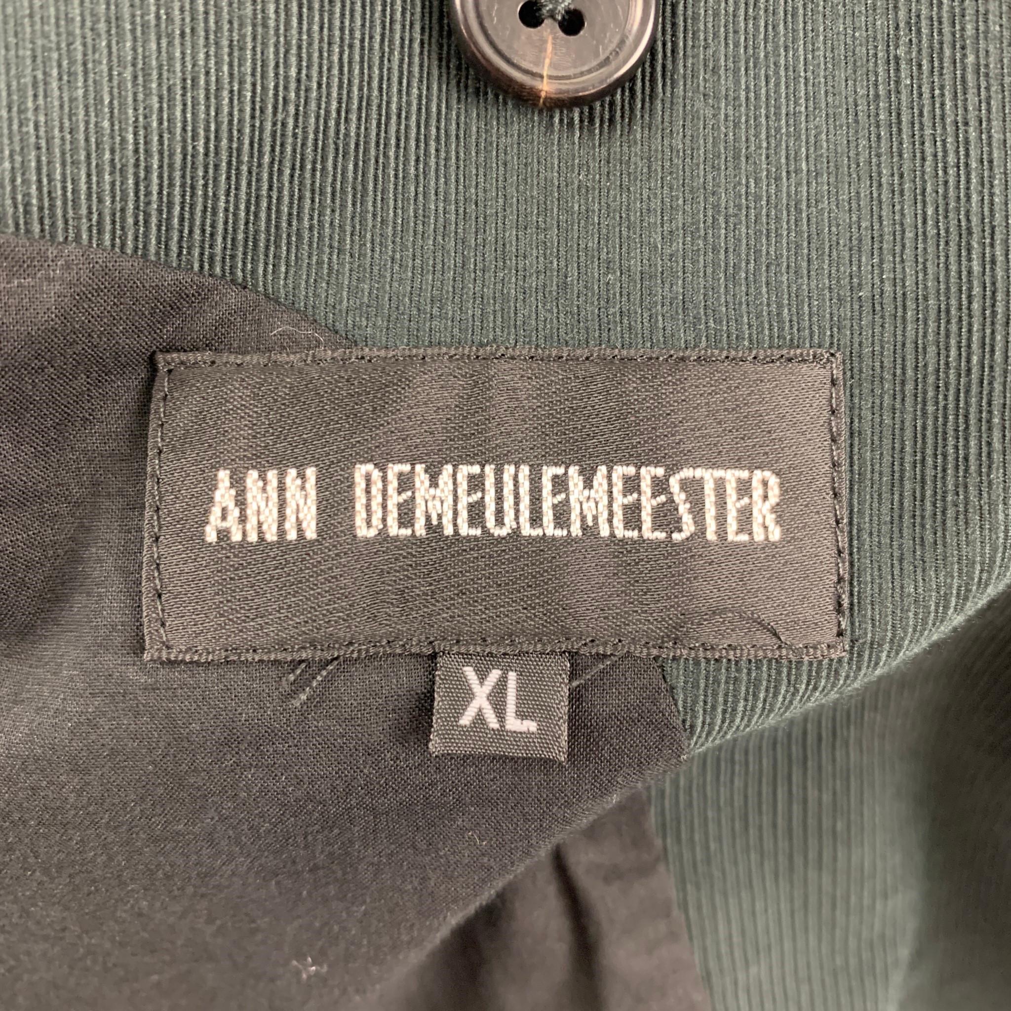 ANN DEMEULEMEESTER coat comes in a charcoal cotton with a front black panel detail featuring a peak lapel, front pockets, full liner, back slit, buttoned sleeve design, and a two button closure. Made in Italy. 

Very Good Pre-Owned