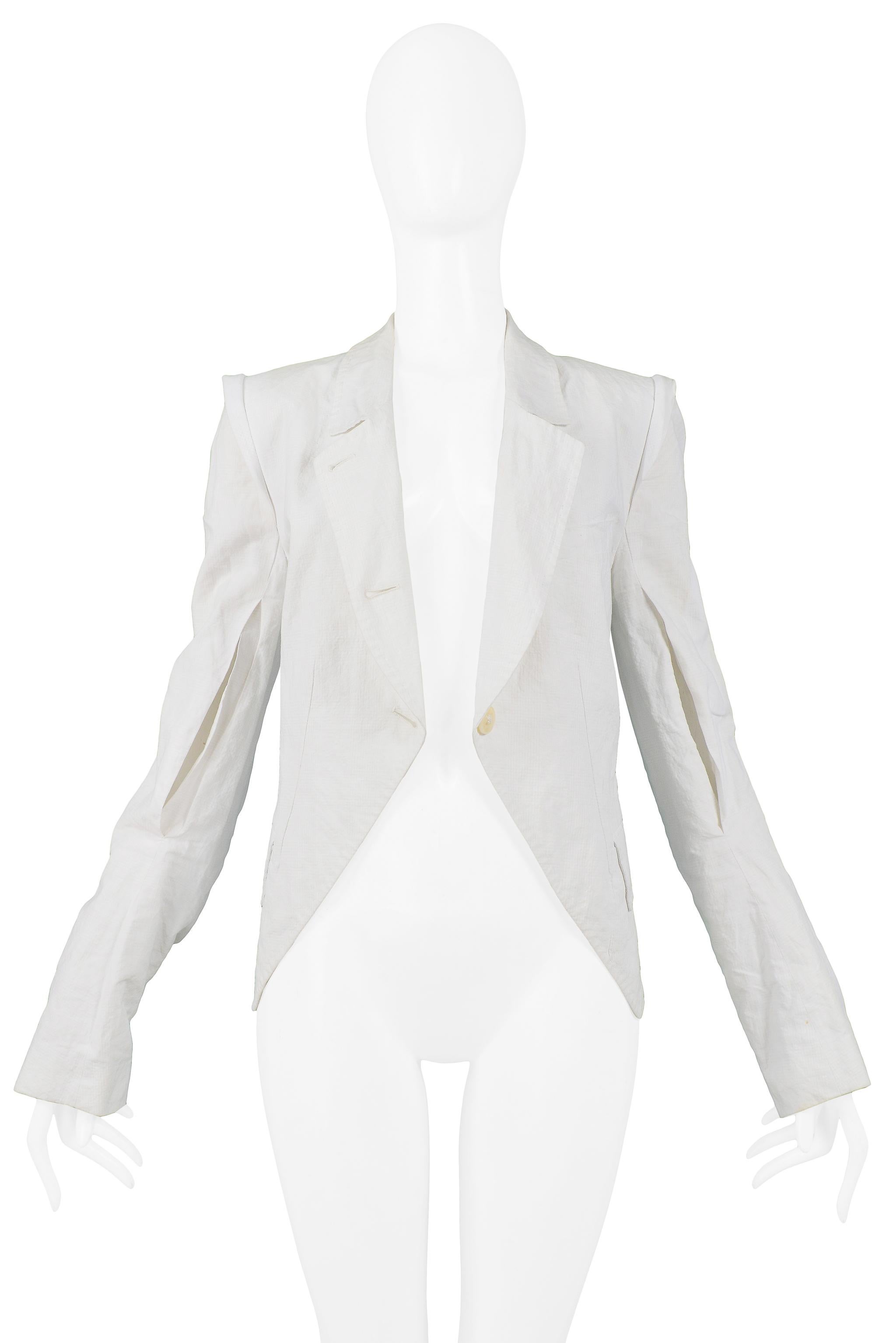 Resurrection Vintage is excited to offer a vintage Ann Demeulemeester white cotton blazer jacket featuring slit sleeve detail, curved asymmetrical 3-button closure, side pockets, button cuffs, and fold-over collar.

Ann Demeulemeester
Size
