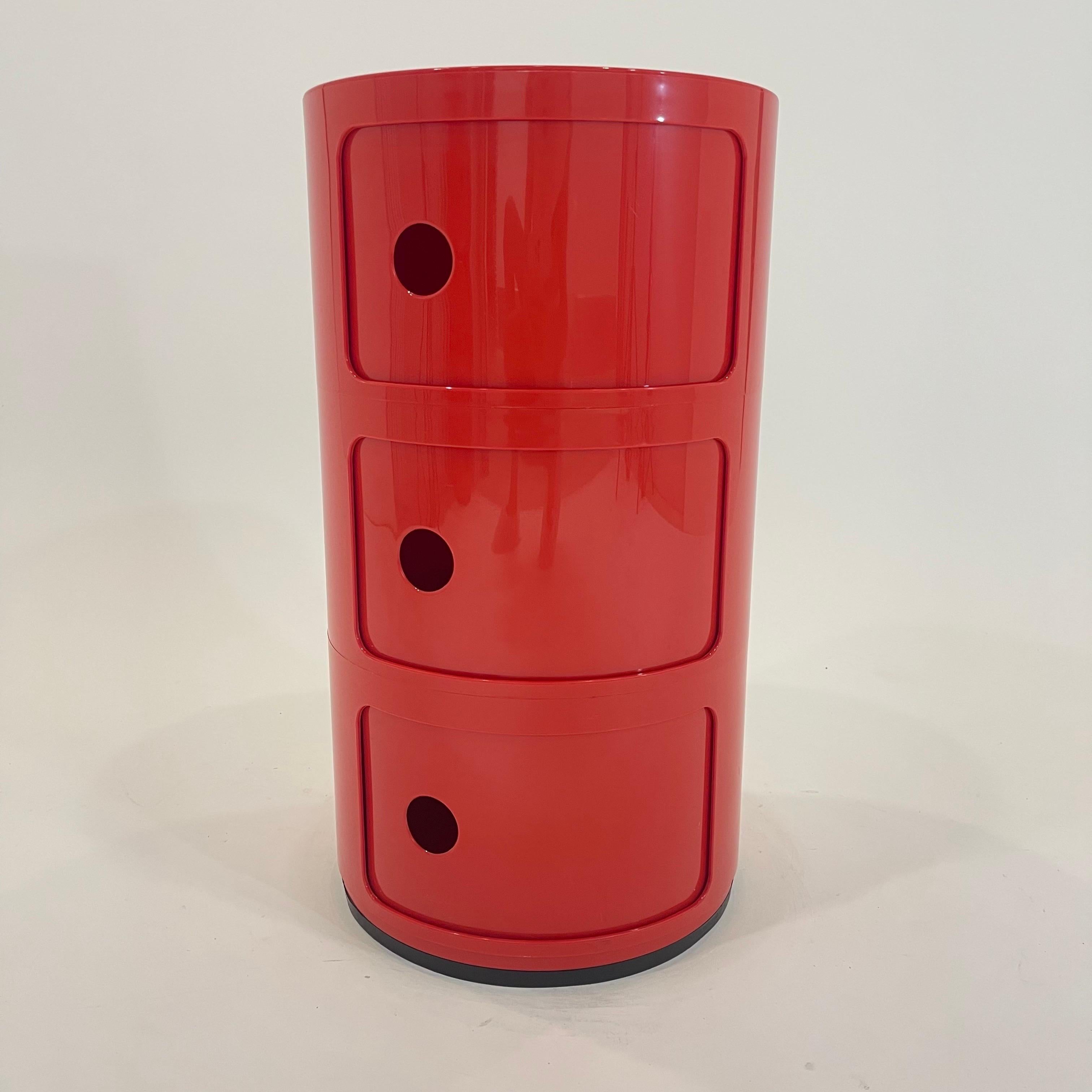 Iconic 3 door Componibili Classic Red Cabinet.  Rendered in batch dyed ABS plastic composed of a 3-tier modular storage system with three sliding doors and a rubber base ring at foot.  Designed by Anna Castelli Ferrieri in 1967 for Kartell, Italy
