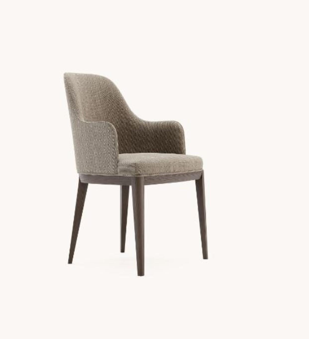 Silla Anna con reposabrazos de Domkapa
Materiales: Fresno teñido fume, tela, zócalo de madera. 
Dimensiones: An 56 x Pr 57 x Al 86 cm. 
También disponible en distintos materiales. 

El diseño de esta silla atemporal es el resultado de un