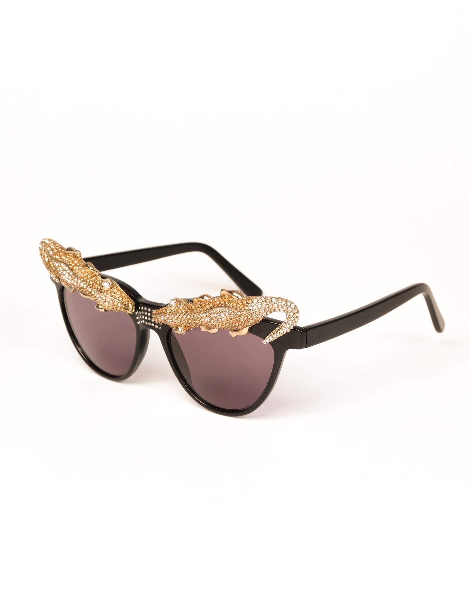 Anna Dello Russo signature over-the-top style is showcased in these alligator topped sunglasses designed for H&M. AdR sunglasses with black lens & frames decorated with . The black lens offer 100% UV protection.

BRAND: Anna Dello Russo X H&M
COLOR: