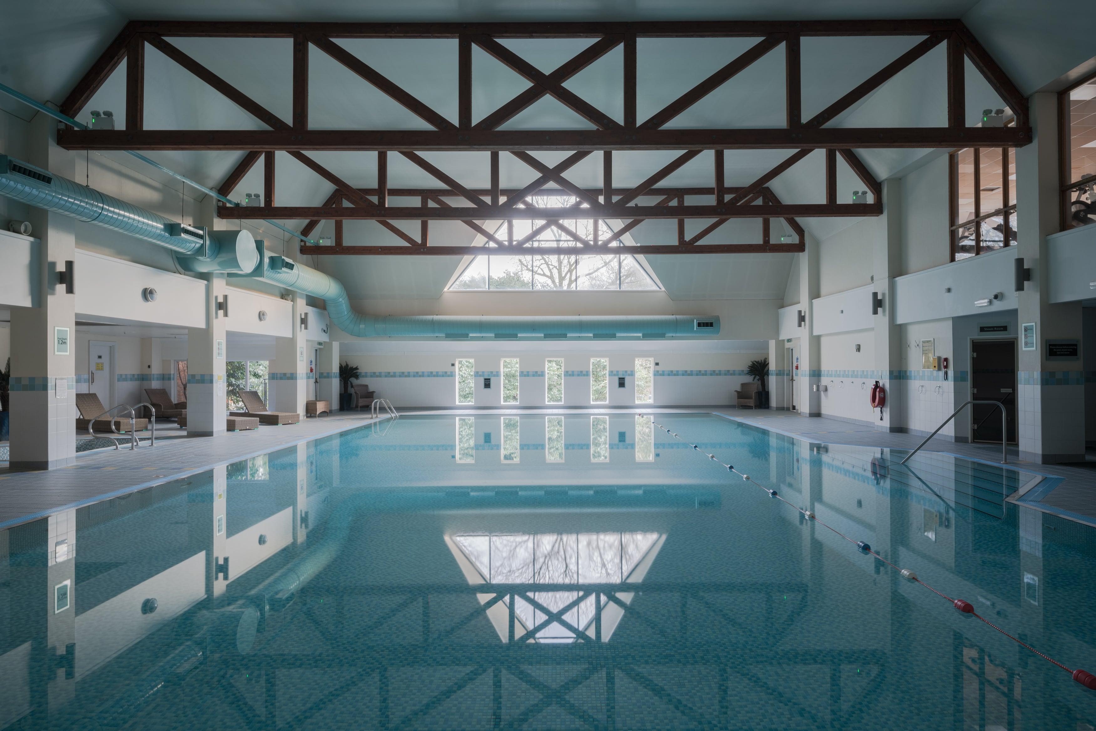 Architectural photo of a pool in British hotel. White frame, museum glass